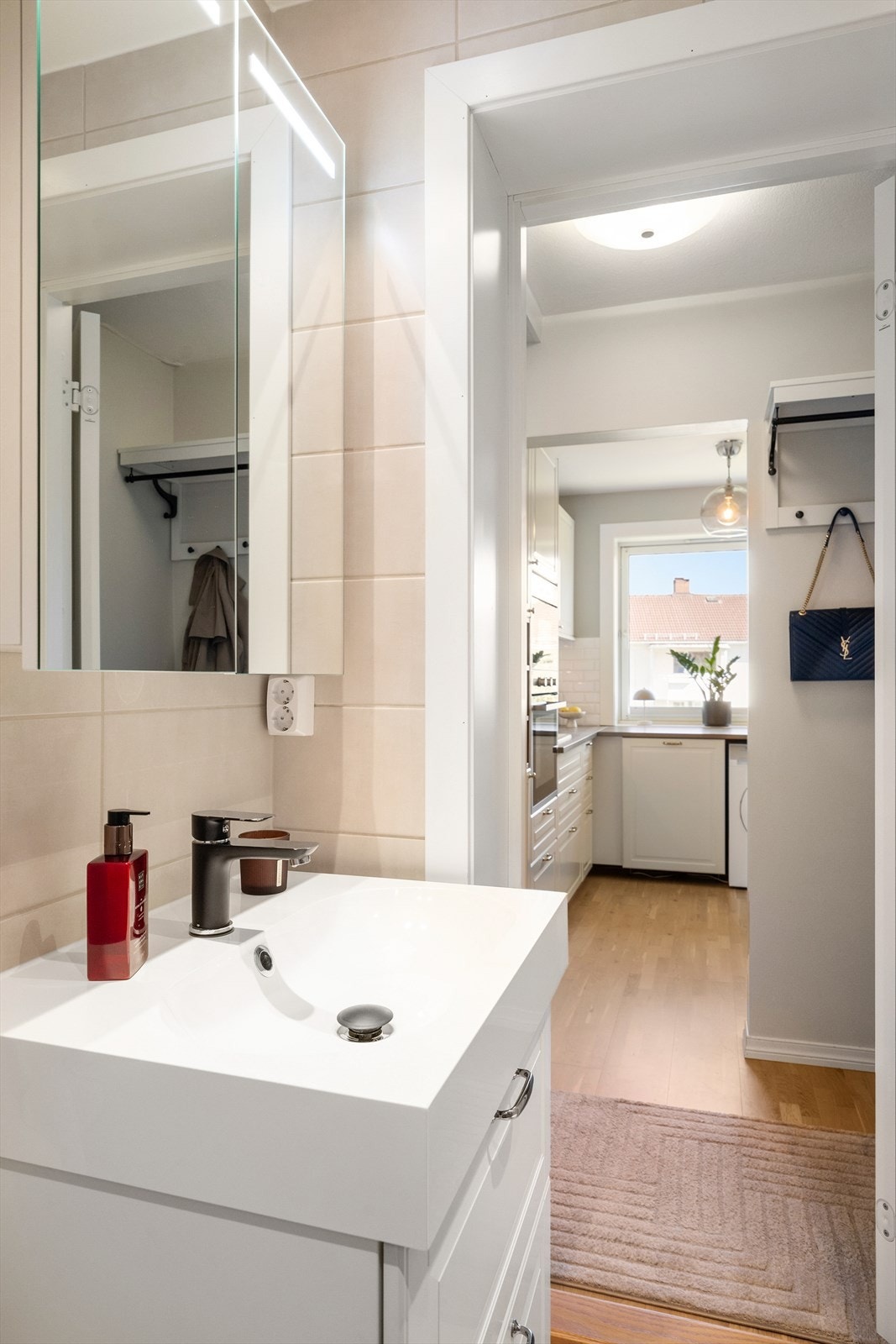 Badet har et flott servantskap med profilerte, folierte fronter og heldekkende servant. Over servanten sitter et speilskap med integrert lysarmatur. Galleribilde