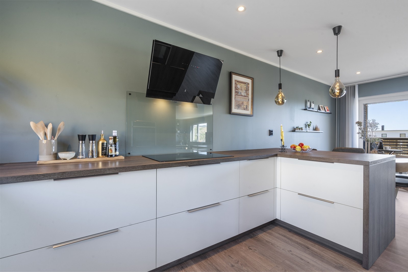 Stue og kjøkken med åpen løsning. En herlig sosial sone. Flott Innredning med glatte fronter og laminat benkeplate. Innredningen har integrert platetopp, stekeovn, oppvaskmaskin og kjøleskap. Galleribilde