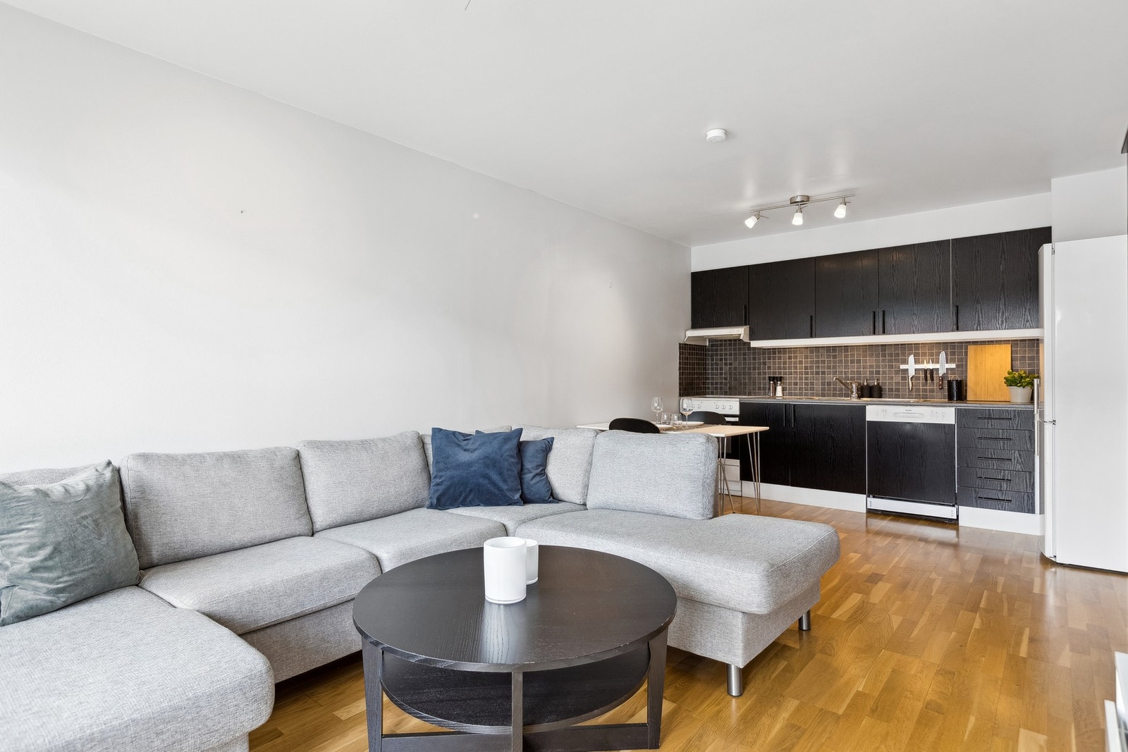 Stue og kjøkken har åpen løsning med plass til både stor sofagruppe og spisebord. Galleribilde