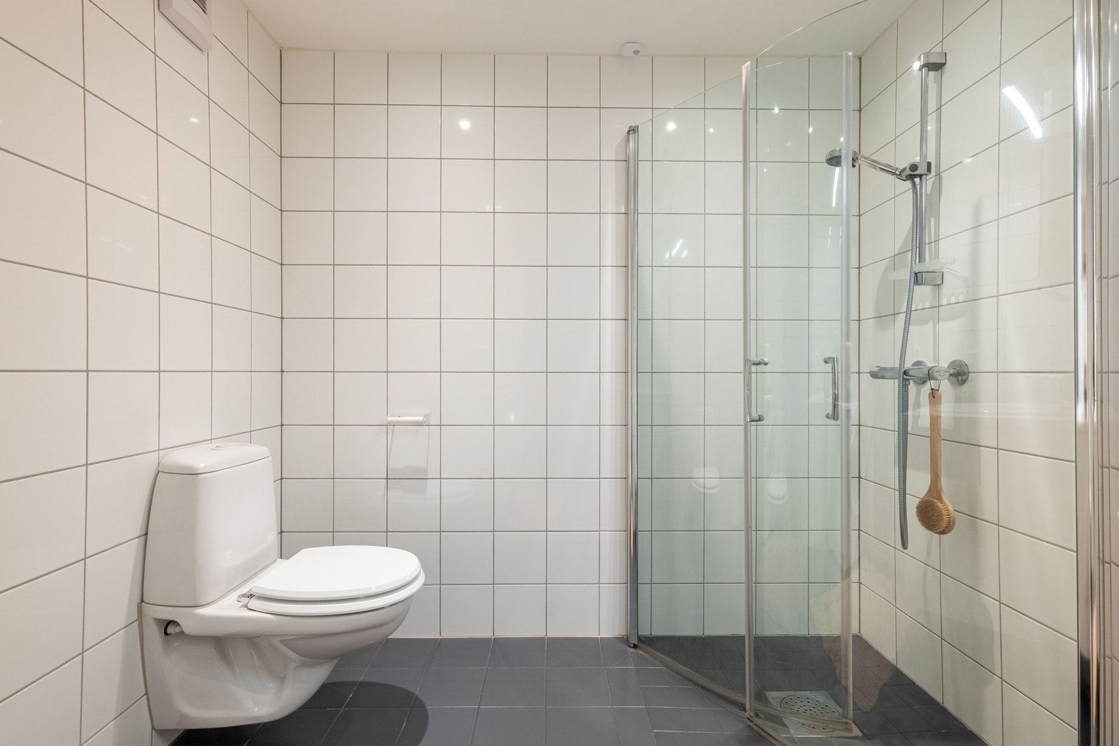 Videre er det vegghengt toalett og dusjhjørne med svingbare glassdører som frigjør plass på gulvet. Galleribilde