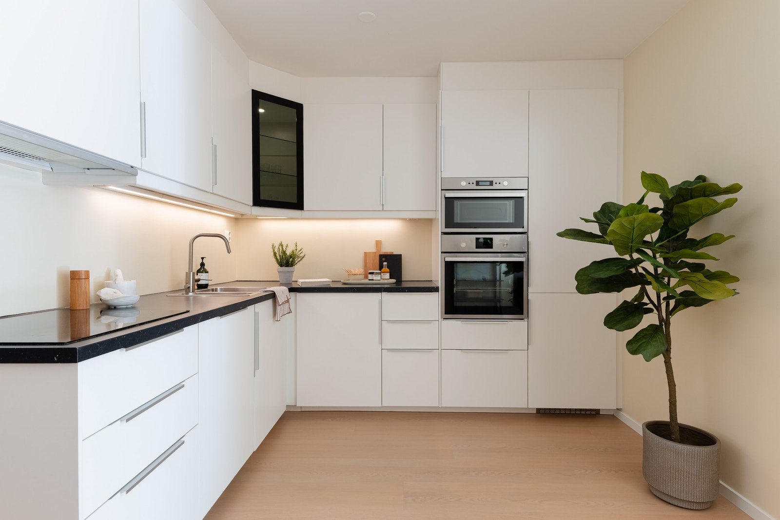 IKEA-kjøkkenet fra 2018 er i hvit, glatt utførelse med laminat benkeplate og nedfelt oppvaskkum med ett-greps armatur. Galleribilde