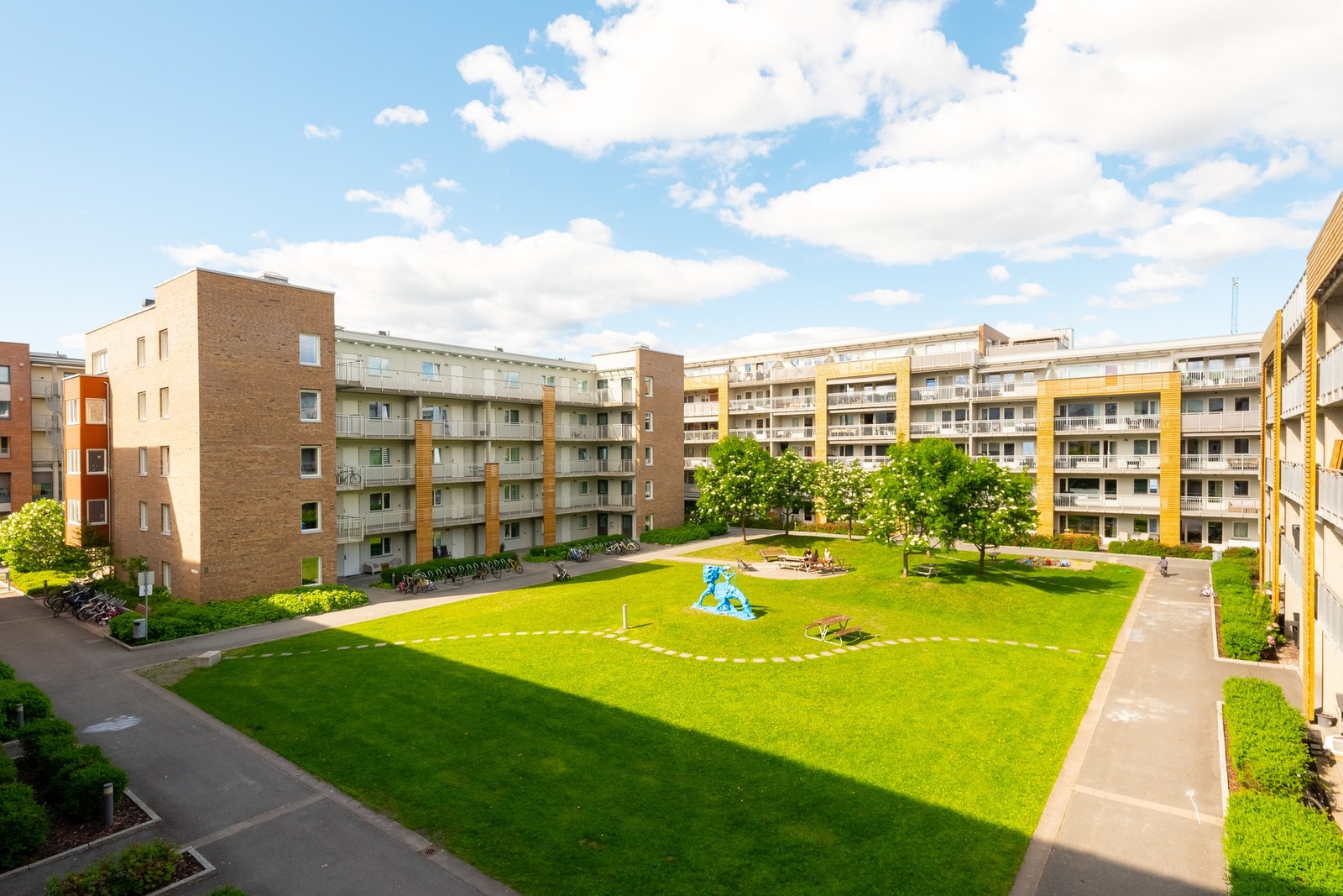 Det er et idyllisk og skjermet gårdsrom til glede for beboerne. Her er det pent opparbeidet med plener, busker, trær og benkeområder. Galleribilde