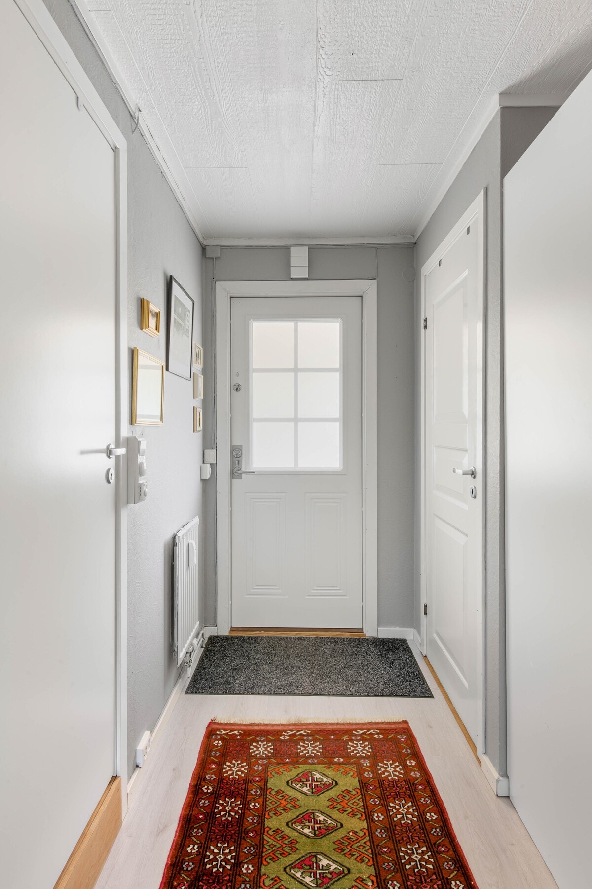 Velkommen inn. Entré/gang med dør til bad og bod. Galleribilde