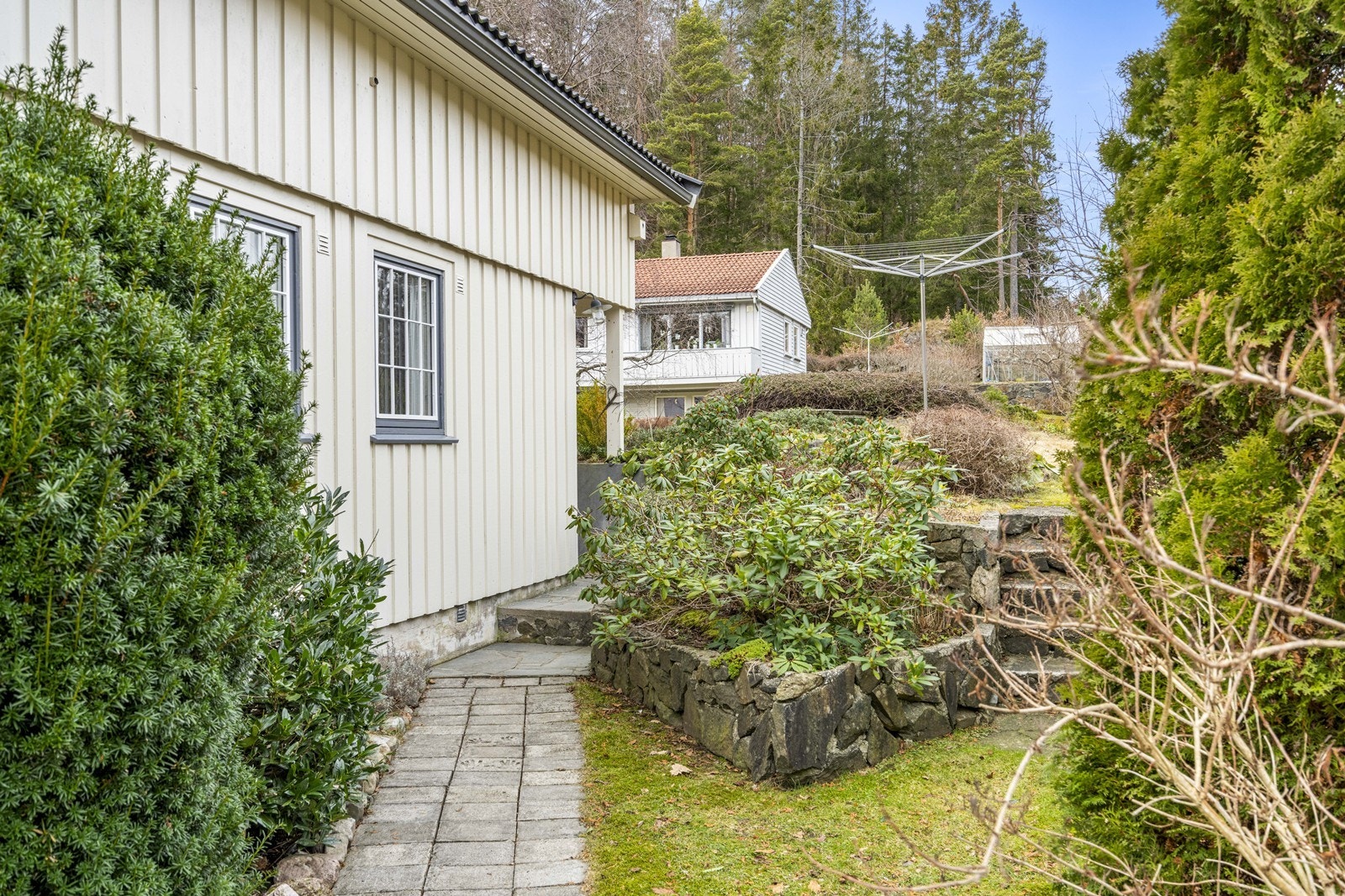 Steinsatt inngangsparti med fine natursteinsmurer og bed Galleribilde