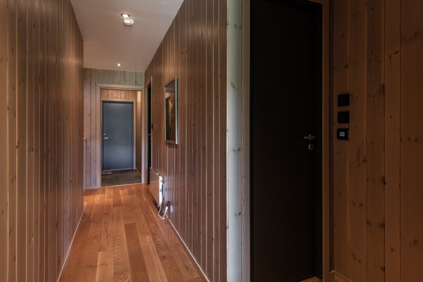 I leilighetens første etasje har man inngang fra bakkeplan, to soverom, bad, badstue og bod Galleribilde