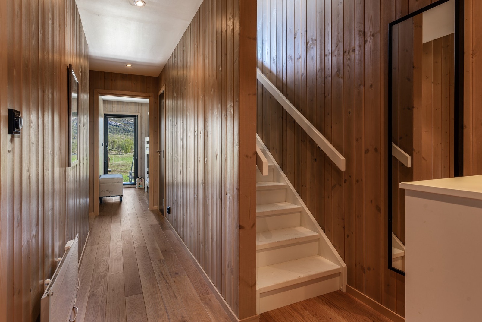 I leilighetens første etasje har man inngang fra bakkeplan, tre soverom, bad, badstue og bod Galleribilde