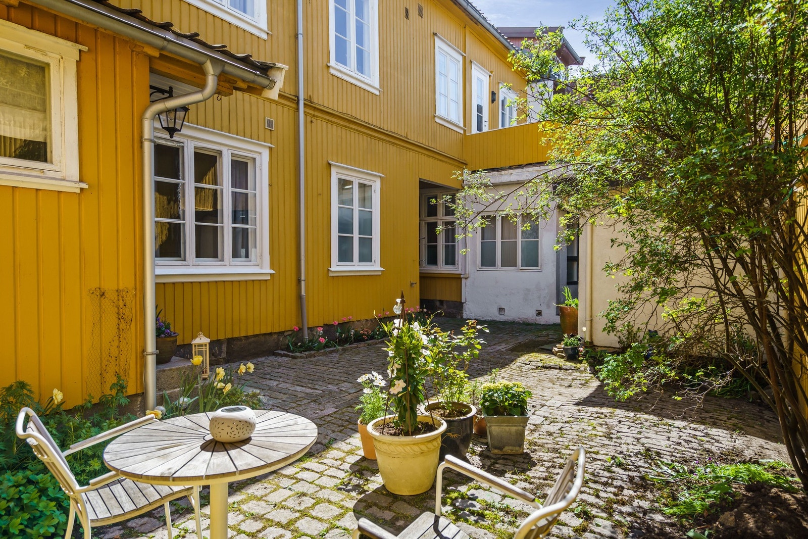 Sjarmerende bakgård med stenlagt uteplass Galleribilde