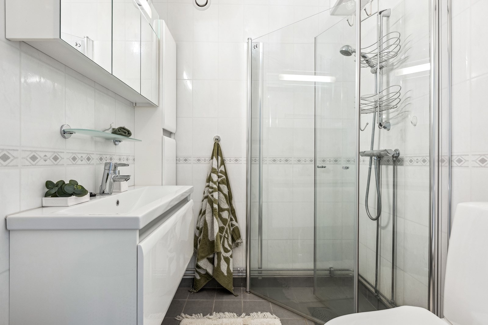 Badet er lyst og har flislagt gulv med varmekabel. Vegger med lyse våtromsplater og innredningen har bra med skapplass. Galleribilde