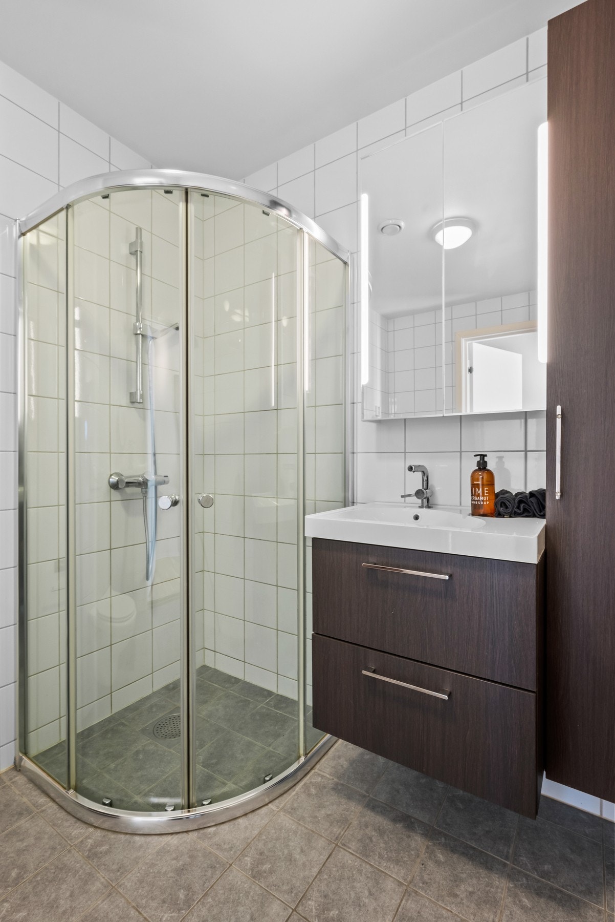 Badet inneholder innredning med servant, vegghengt toalett og dusjhjørne. Galleribilde