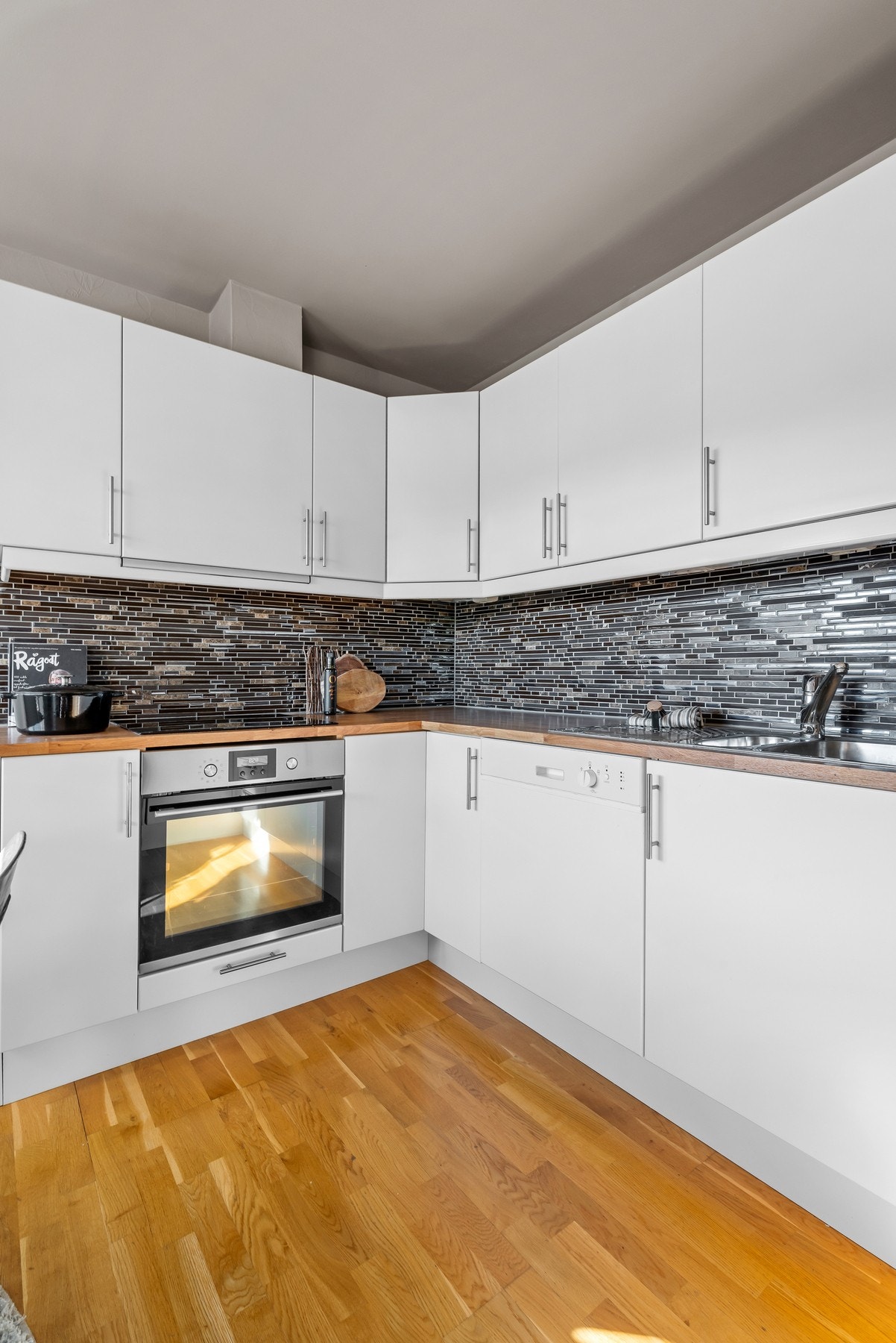 Innbydende og delikat kjøkken med integrert platetopp, stekeovn og oppvaskmaskin. Galleribilde