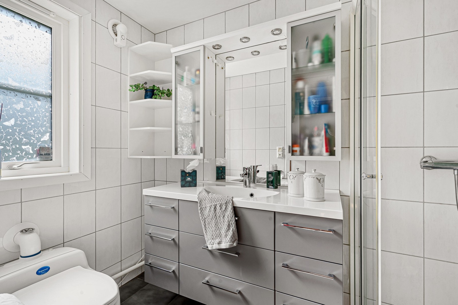 Stilrent bad med dusjhjørne, servant og separett toalett - lyse flater og moderne uttrykk Galleribilde