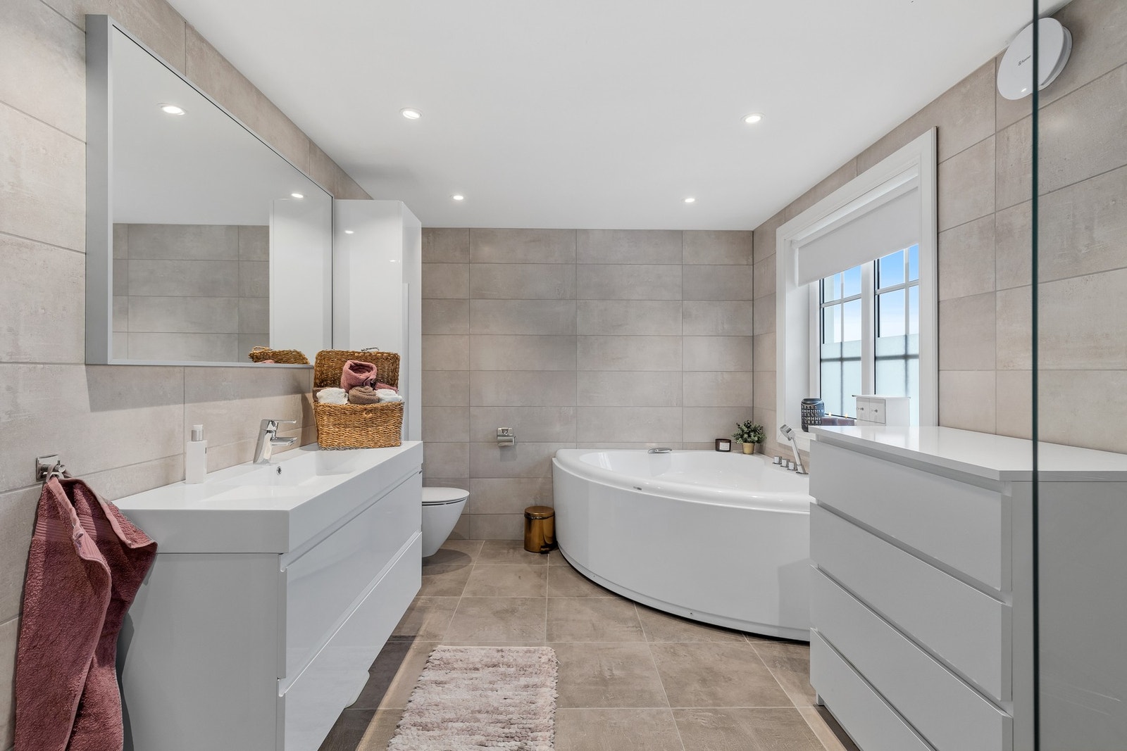 Badet har blant annet dusjnisje med glassvegg og dusjgarnityr montert på vegg. Galleribilde