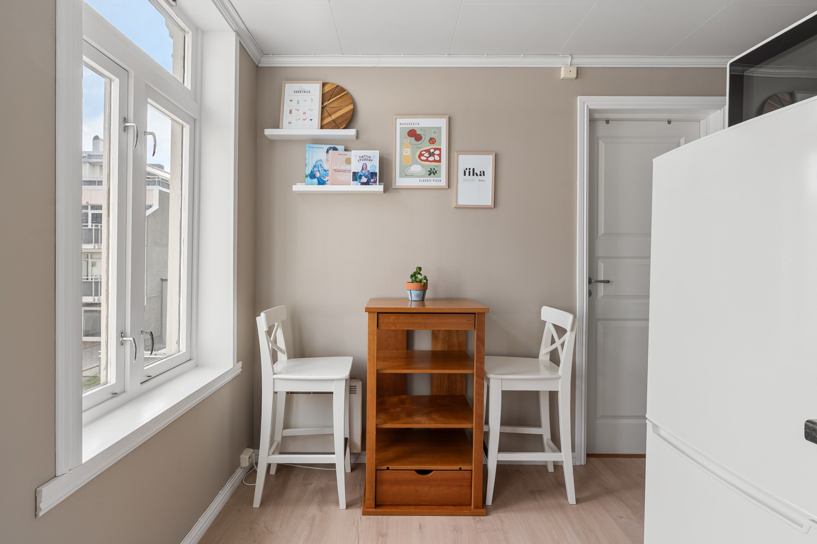 Kjøkkenet har stort vindu som gir gode arbeidsforhold. Det er plass til spisebord på kjøkkenet.