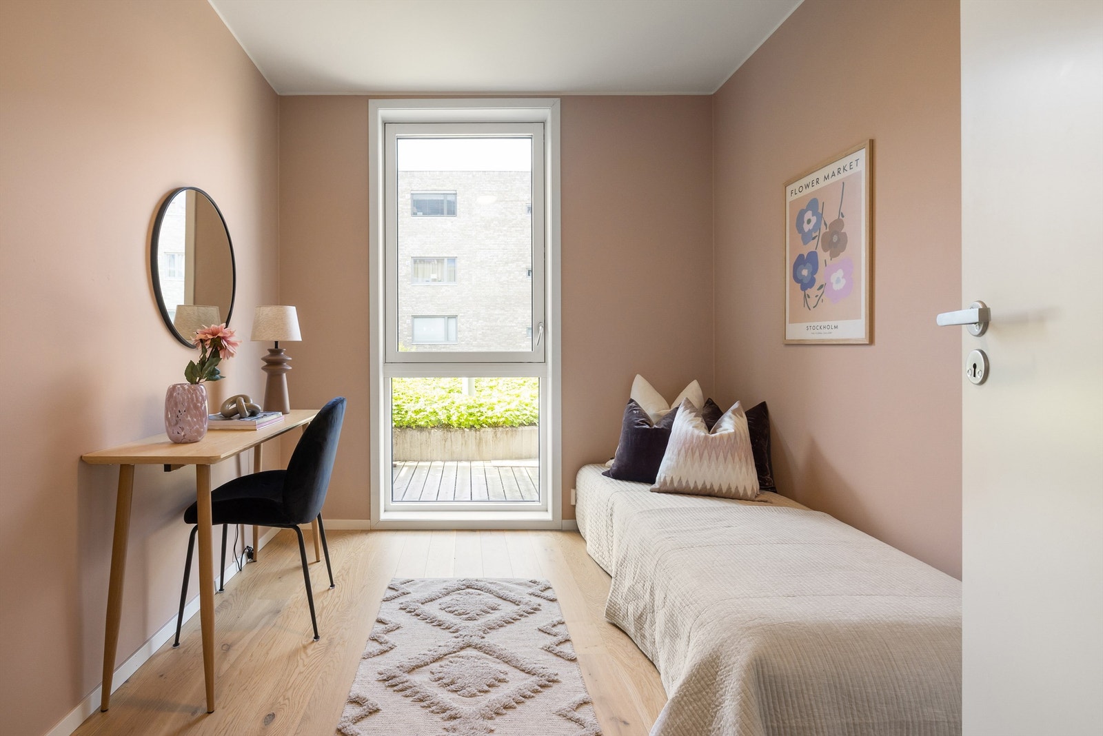Soverommet er innredet med enkeltseng, skrivebord og en frittstående garderobe, og malt i en varm, støvet rosatone som skaper en lun atmosfære. Galleribilde