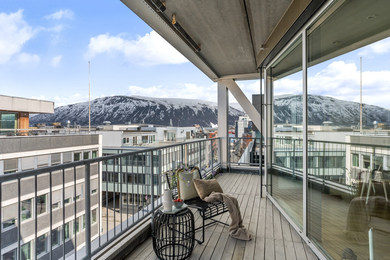 Utgang til balkong med utsikt over byen og mot Tromsdalen, Ishavskatedralen og Fjellheisen.