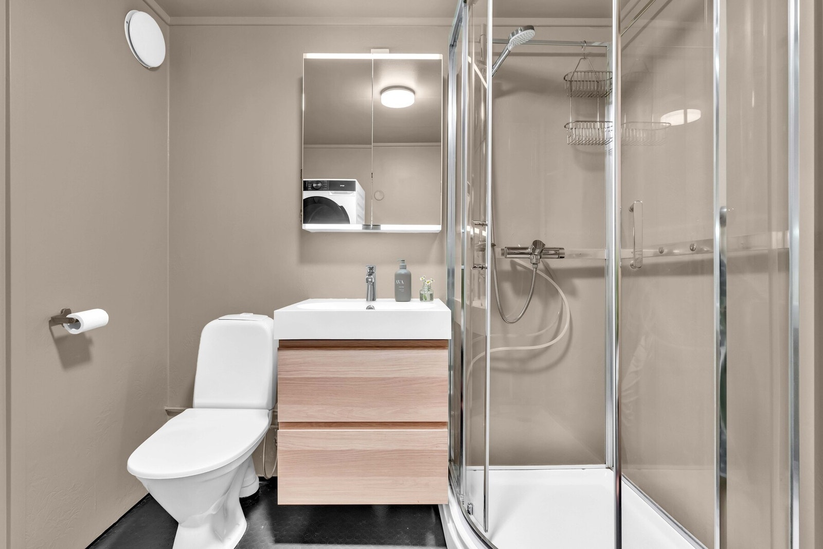 Innredningen består av et servantskap, og speil med belysning. Videre er badet utstyrt med toalett og dusjkabinett. Galleribilde