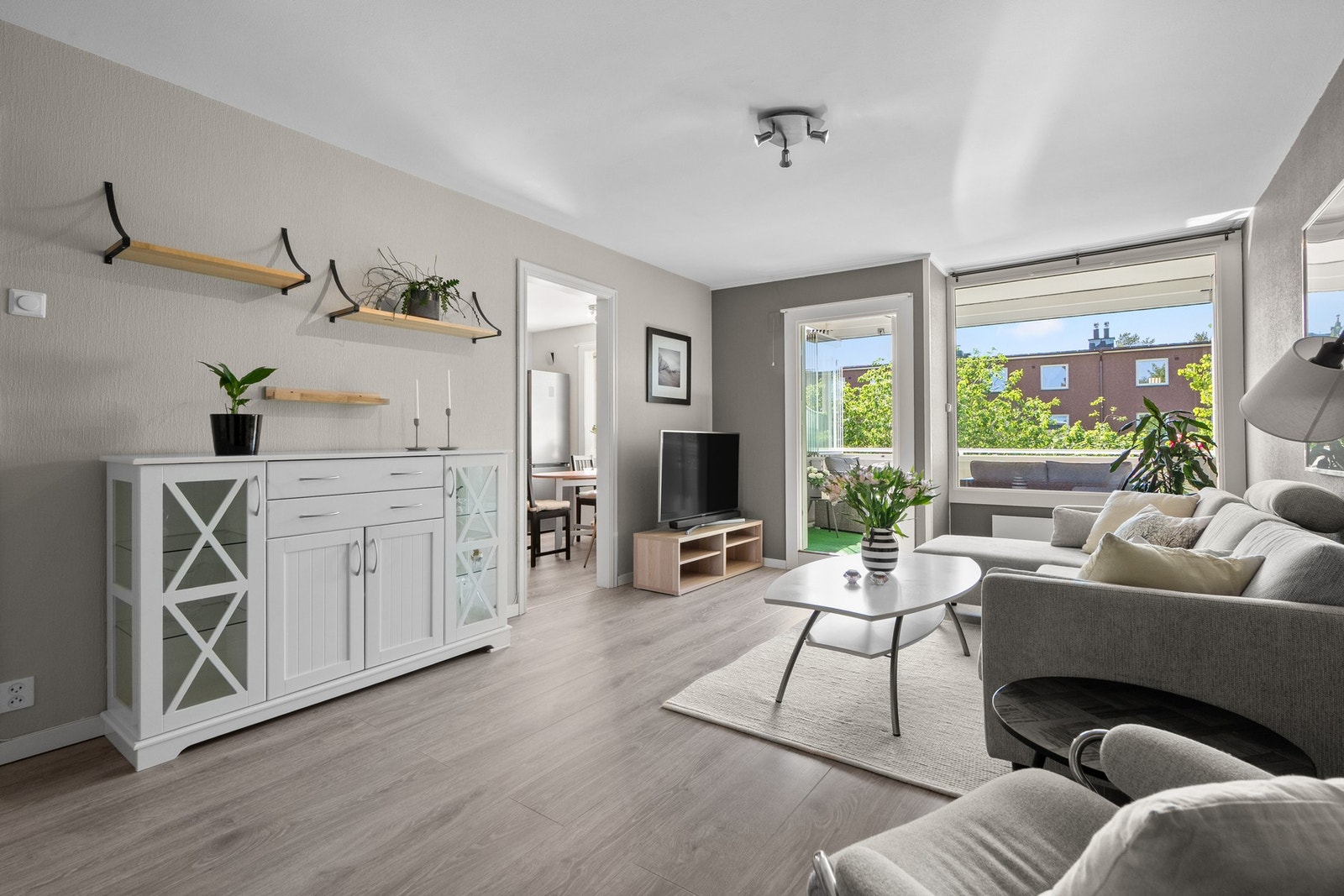 Stue med fint lysinnslipp og pen 1-stavs laminat. Galleribilde