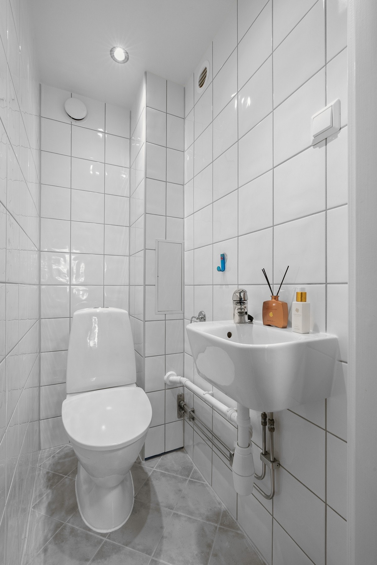 Separat wc-rom med fliser, downlights og en enkel servant. Galleribilde