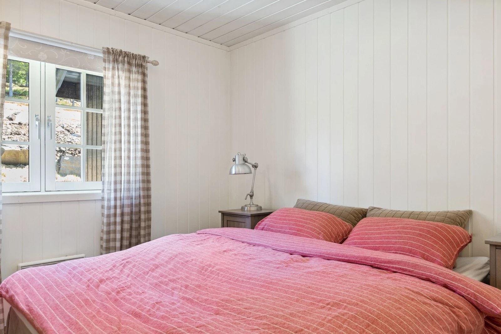 Romslig soverom med plass til dobbeltseng, nattbord på begge sider og en praktisk garderobeløsning som sikrer gode oppbevaringsmuligheter Galleribilde