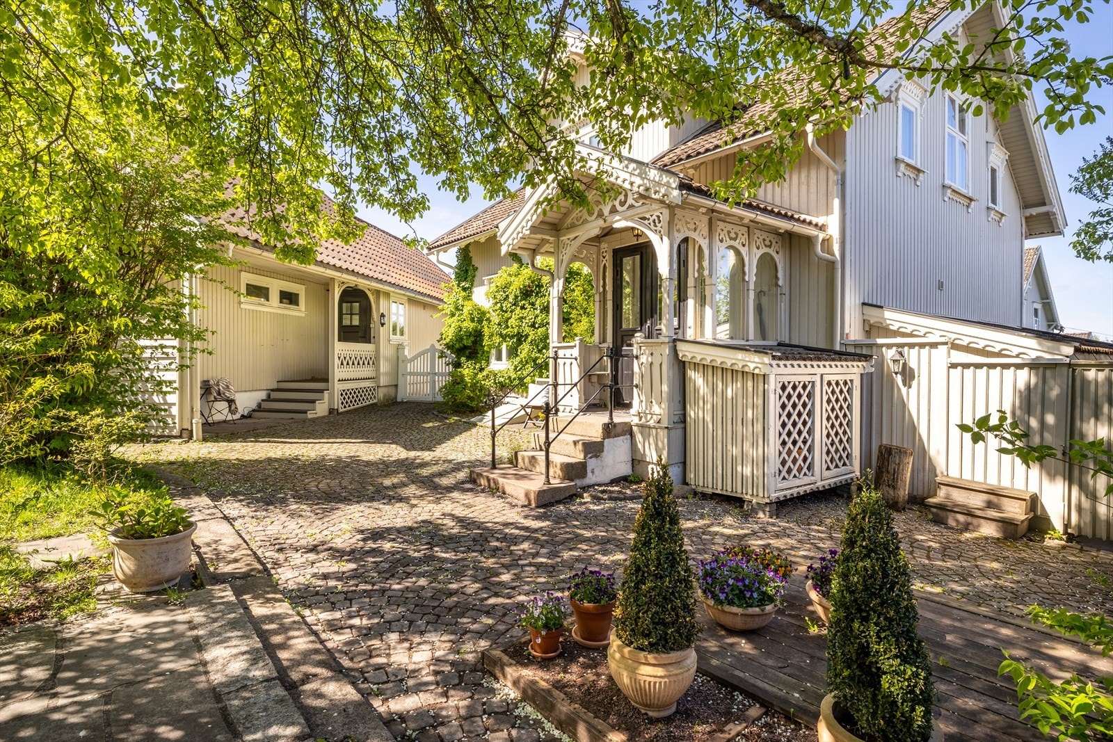 Her er det nydelig brostein, prydbusker og trær. Det er flere lune uteplasser og en koselig hagestue. Galleribilde