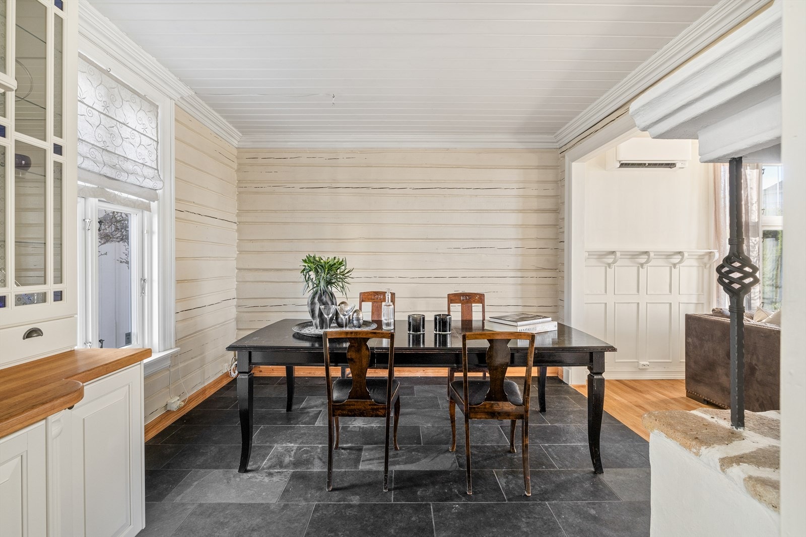 Mellom kjøkkenet og stuen er det god plass til spisestuen. Legg også merke til den nydelige og originale tømmerveggen. Galleribilde