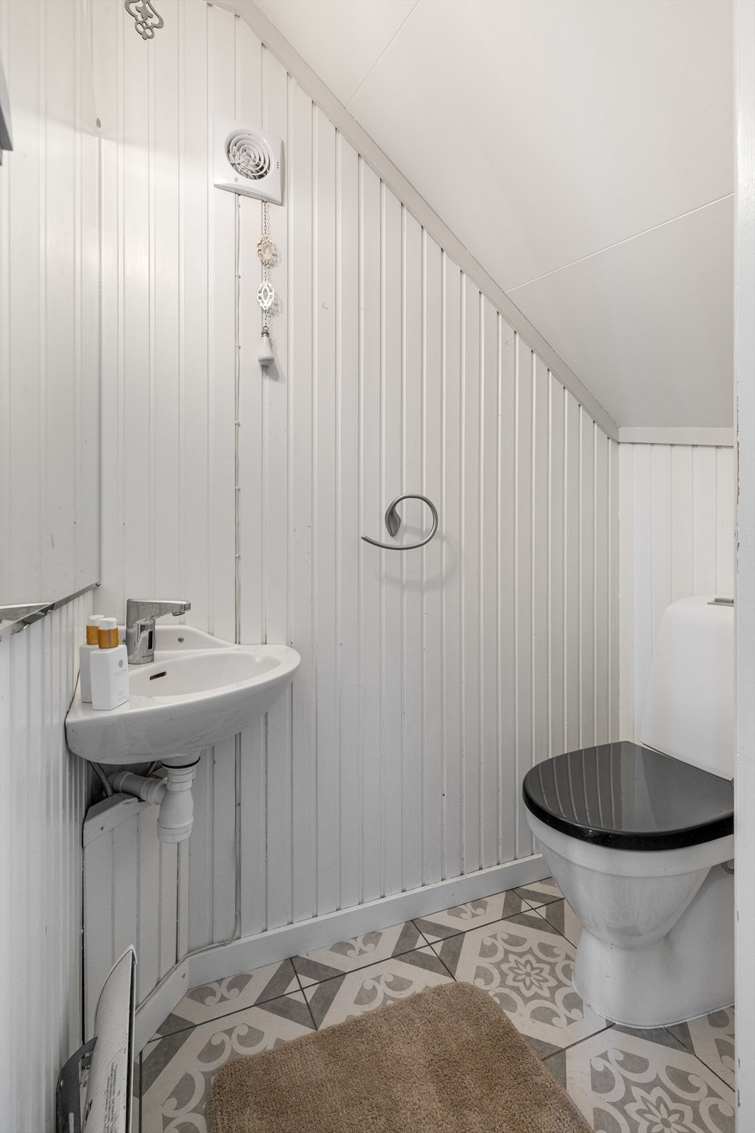 I hendig tilknytning til entreen i første etasje er det et separat wc-rom under trappen - perfekt ved besøk av gjester. Galleribilde