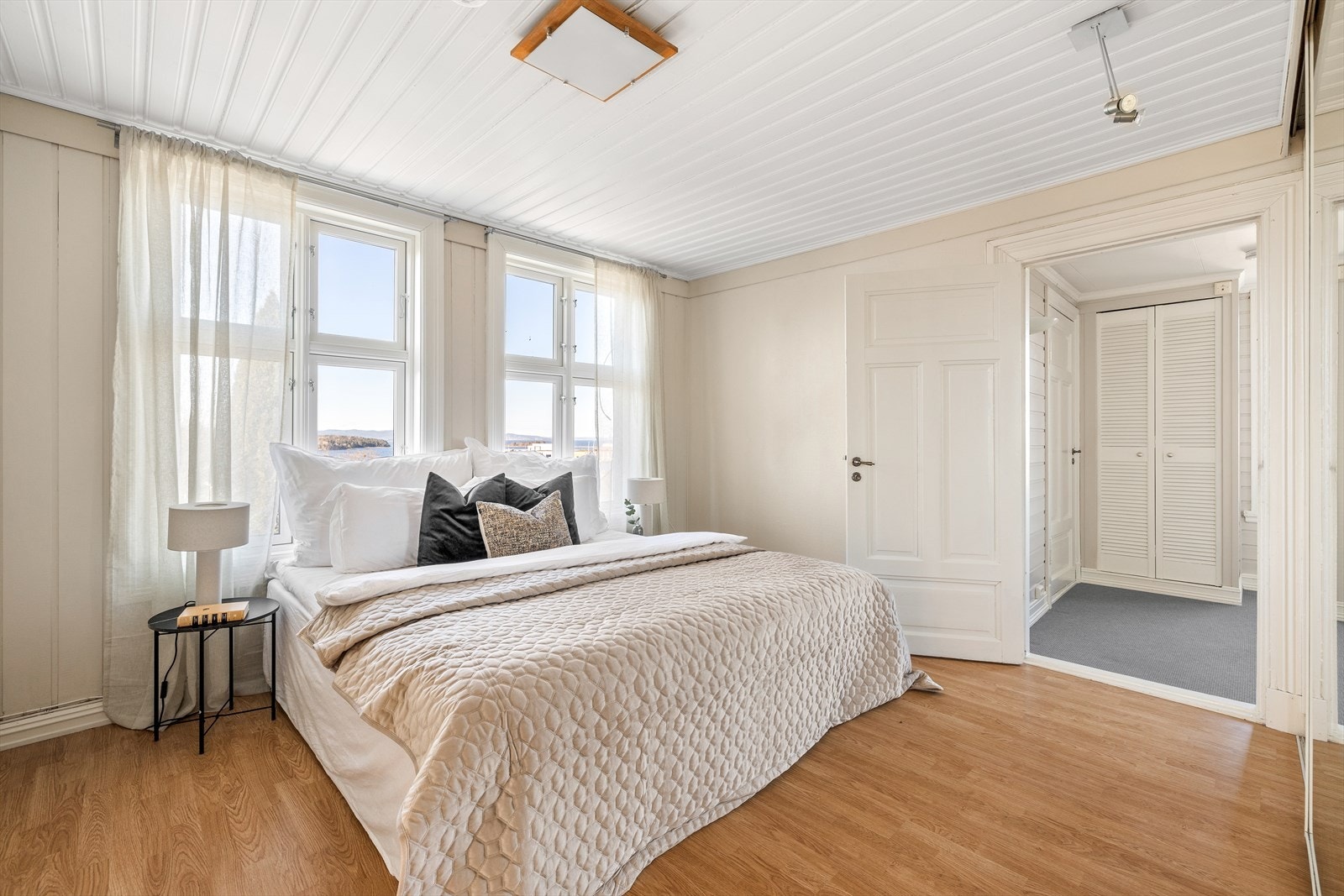 Lyst, delikat og romslig soverom med plass til dobbeltseng og tilhørende møblement. Galleribilde