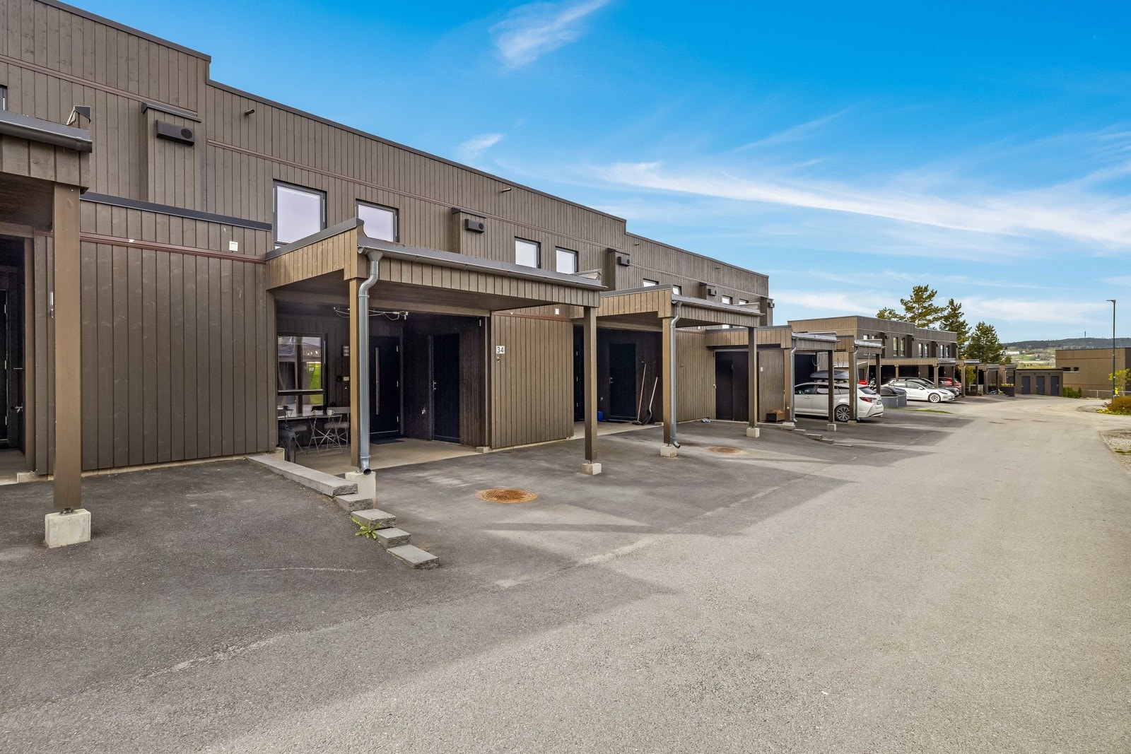 Rekkehuset har asfaltert adkomst og enkel parkering i carport ved siden av inngangspartiet. Galleribilde
