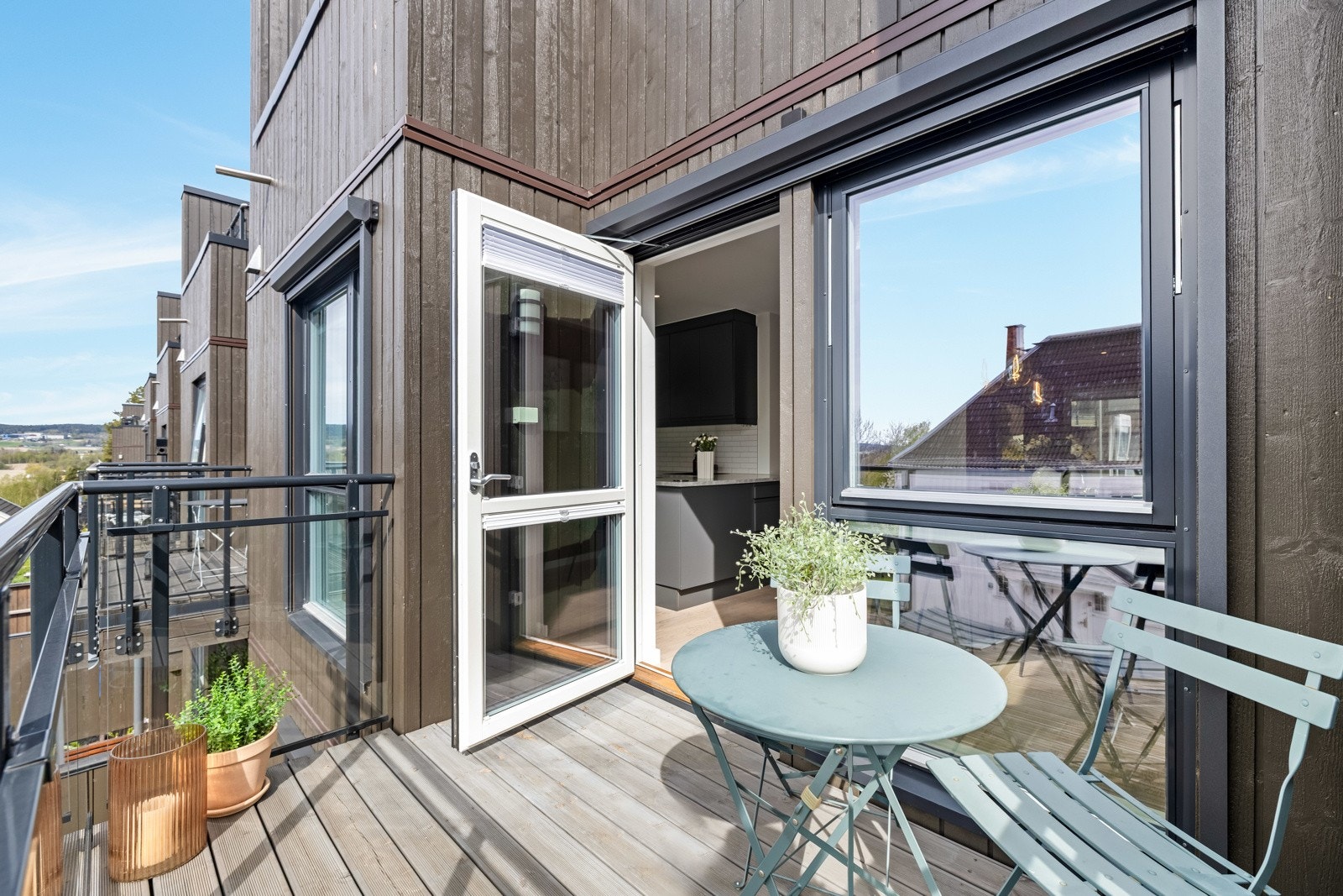 Balkongen har rekkverk i glass, sol og utsikt. Galleribilde