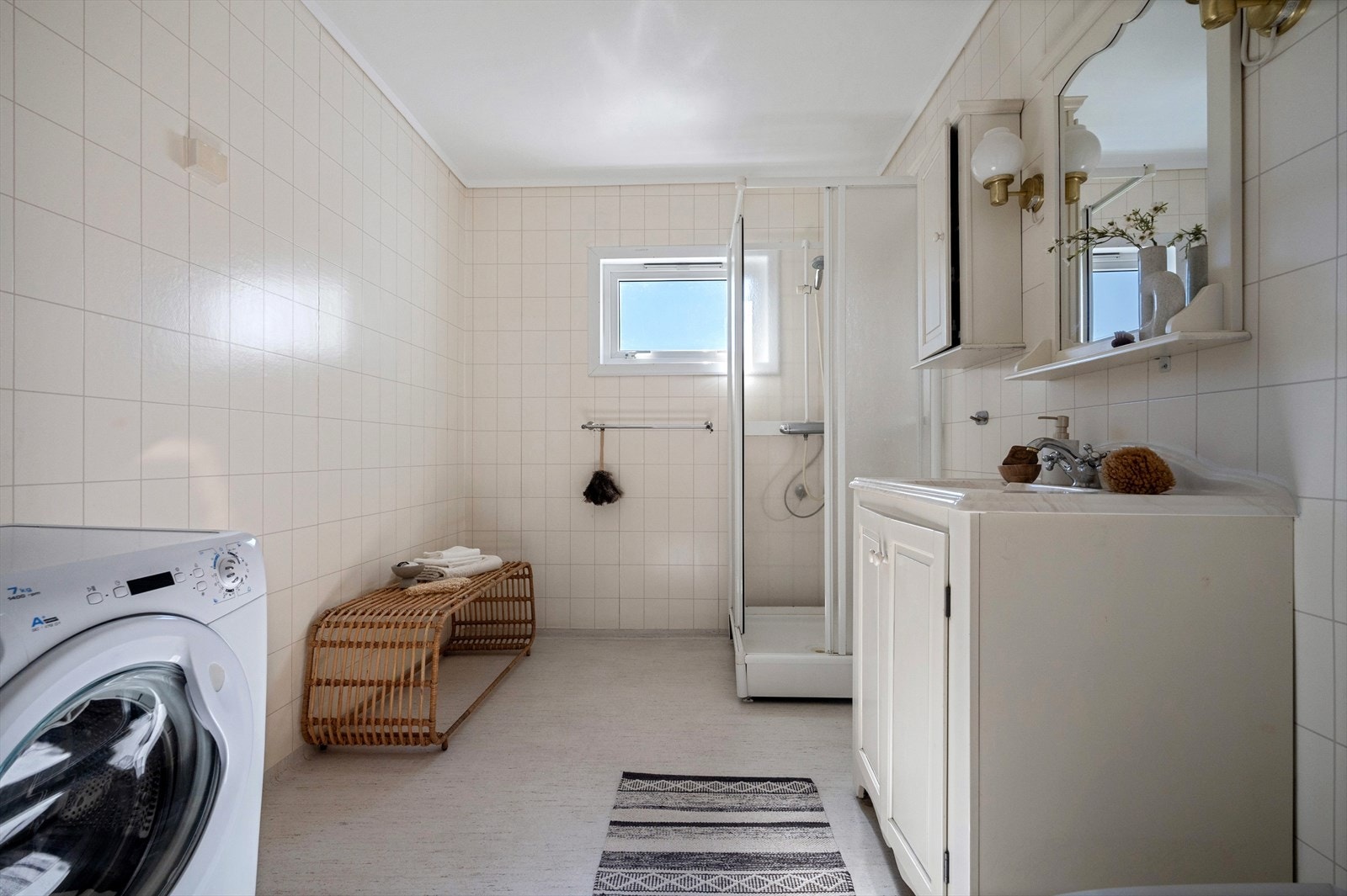 Badet er utstyrt med dusjkabinett, servantmøbler, toalett og overskap. Galleribilde