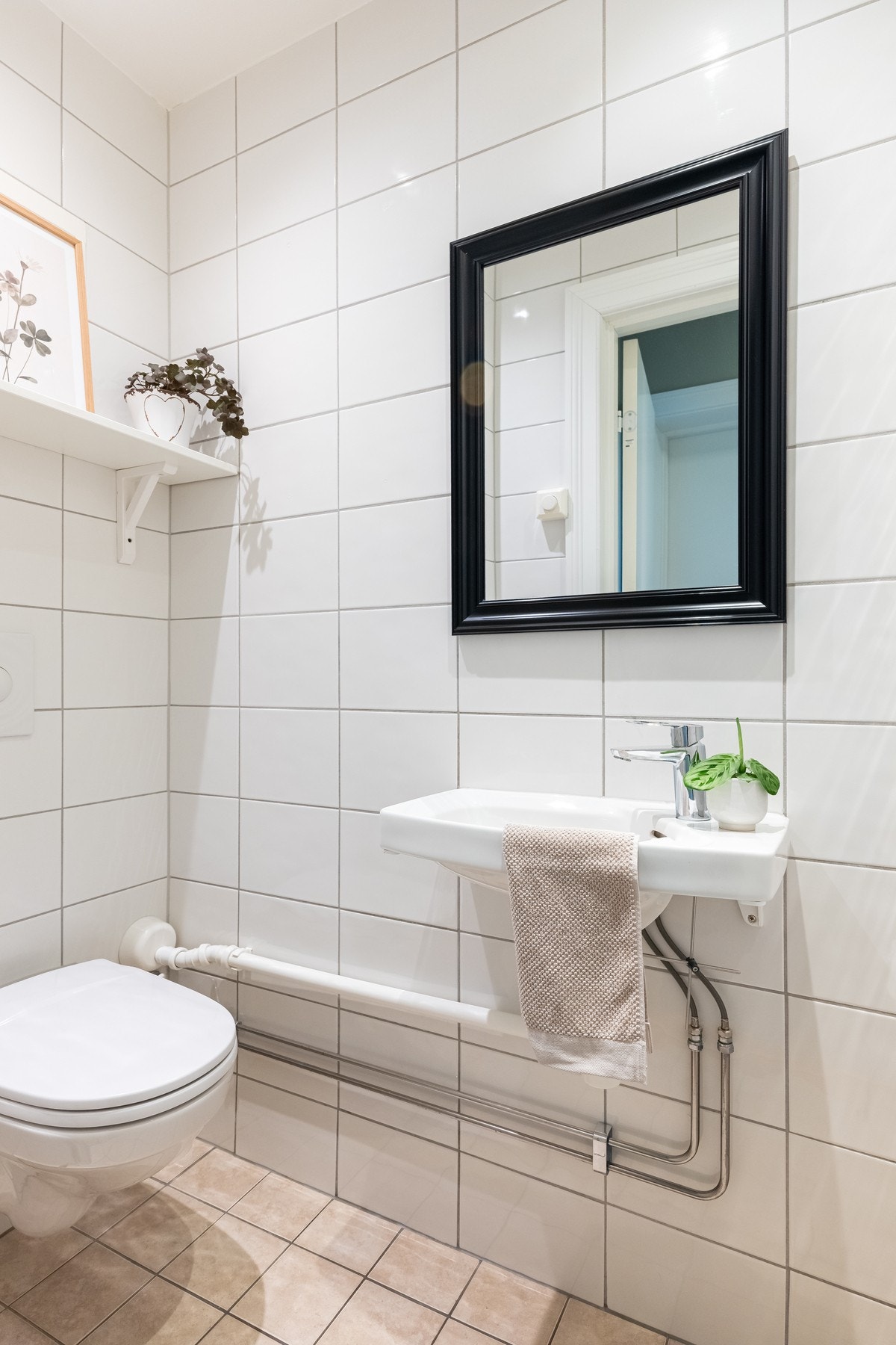 Toalettrommet har vask, speil og toalett. Flislagte vegger og gulv. Galleribilde