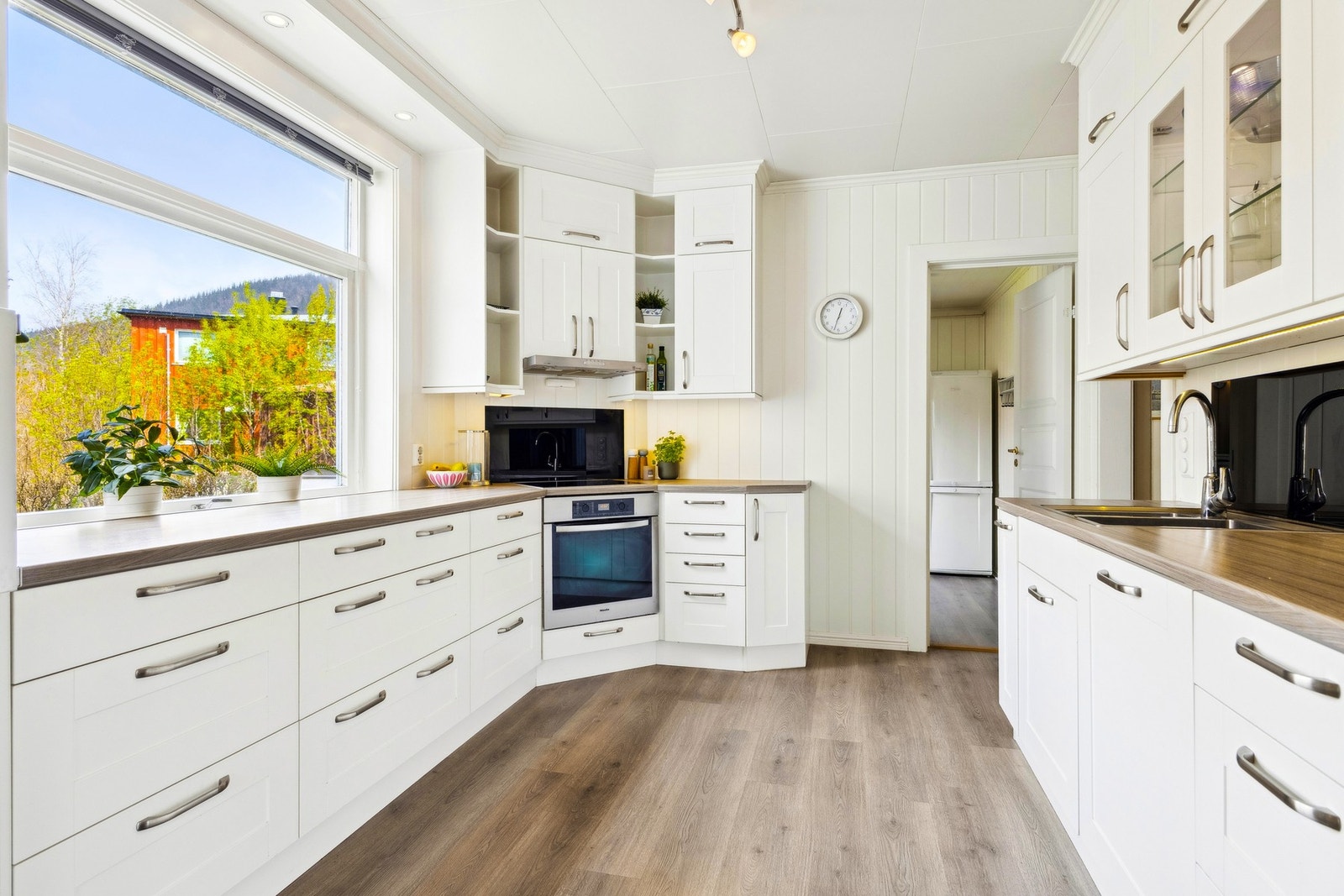 Pent og funksjonelt kjøkken med rikelig benkeplass og skap, tilrettelagt for matlaging og trivsel. Galleribilde