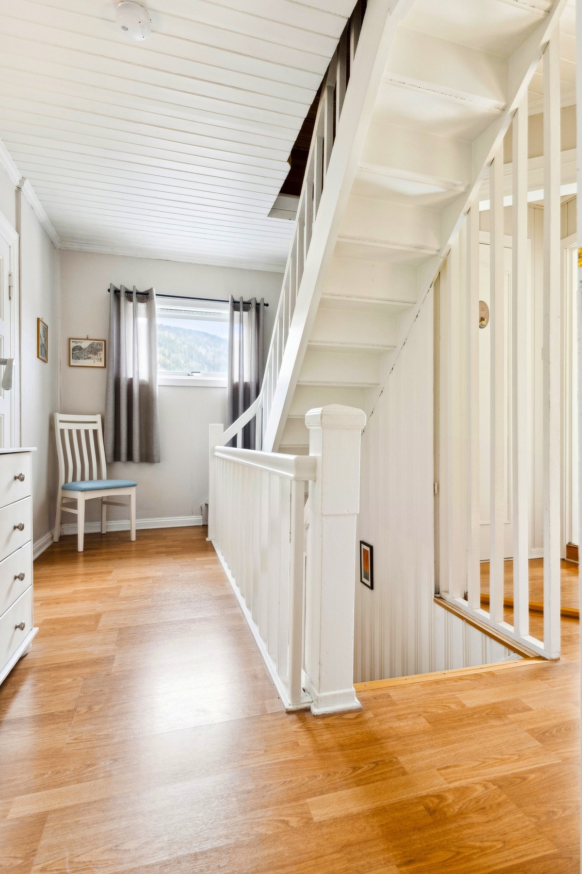 Lys og åpen gang med trappeløp som skaper en naturlig forbindelse mellom etasjene. Galleribilde