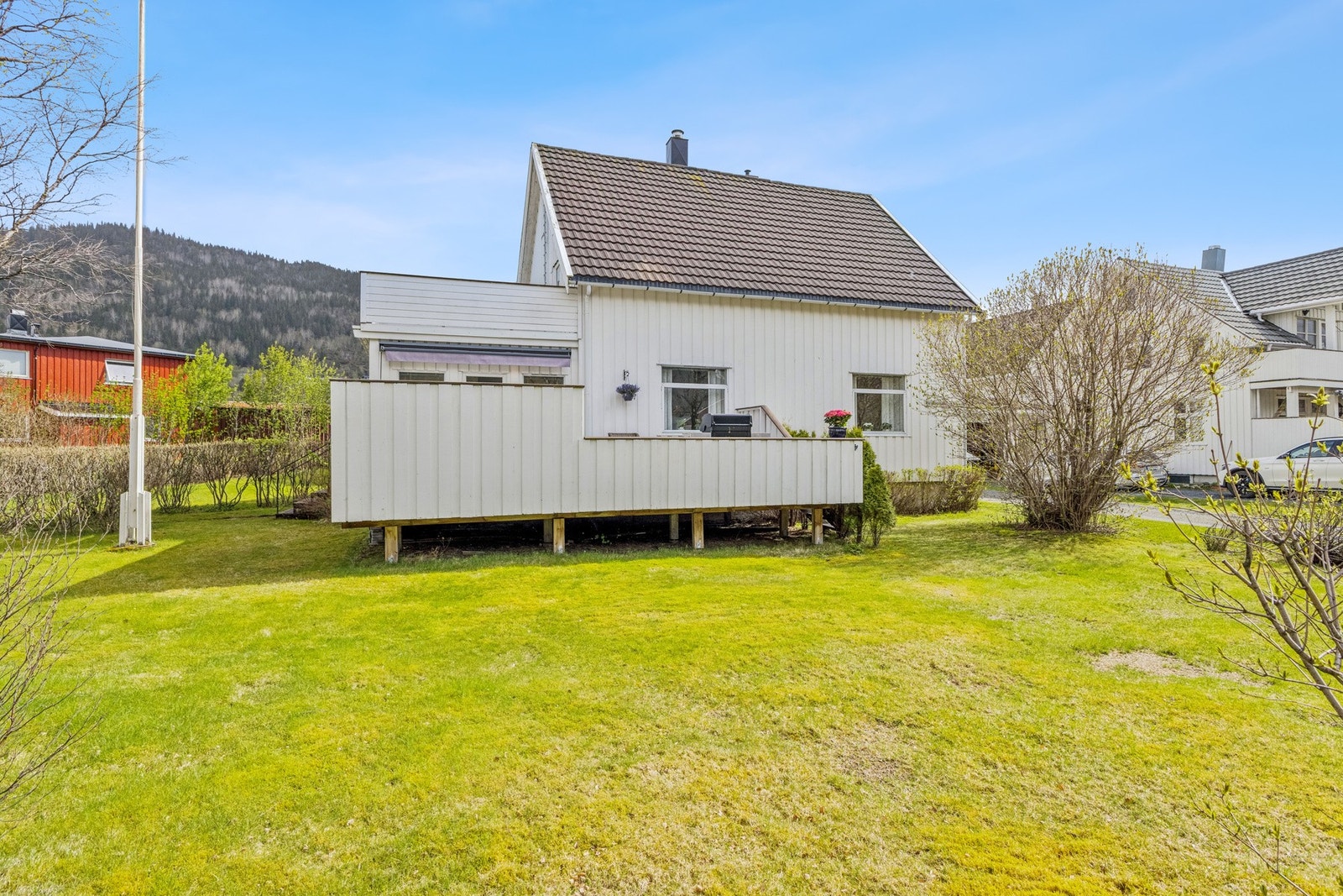 Flat og solrik tomt med plen og beplantning, barnevennlig og lettstelt. Galleribilde
