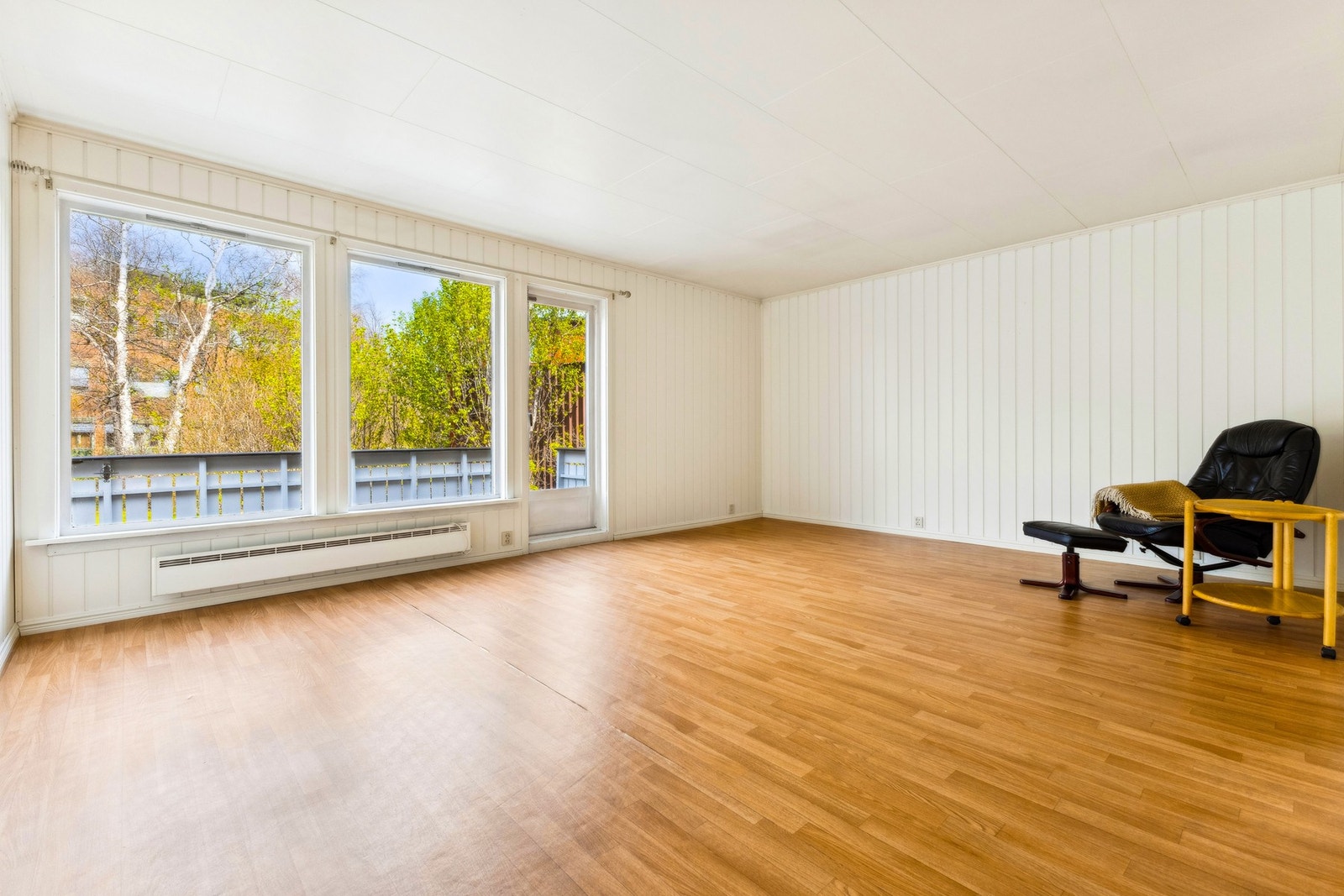 Lys og romslig stue med store vinduer, med utgang til egen terrasse og hageområde. Galleribilde