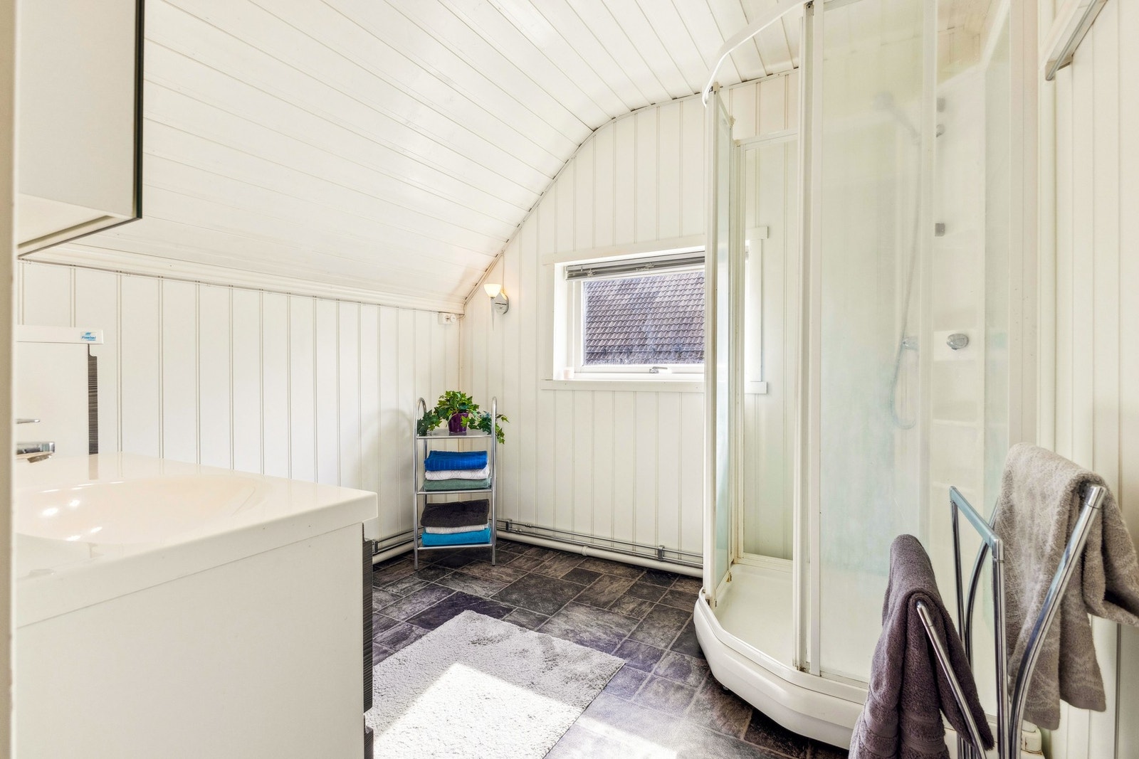 Lyst og pent bad med dusjkabinett og praktiske løsninger. Galleribilde