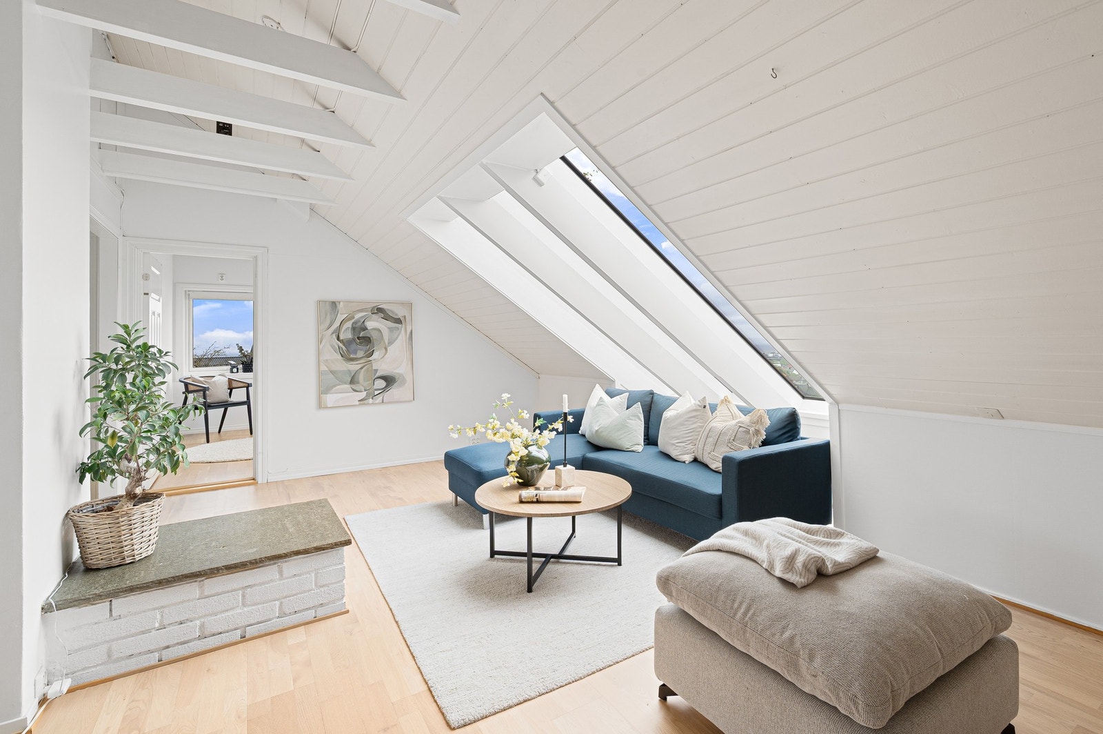 Stuen i toppetasjen byr på god takhøyde, synlige bjelker og et flott lysinnslipp som skaper en herlig atmosfære. Galleribilde