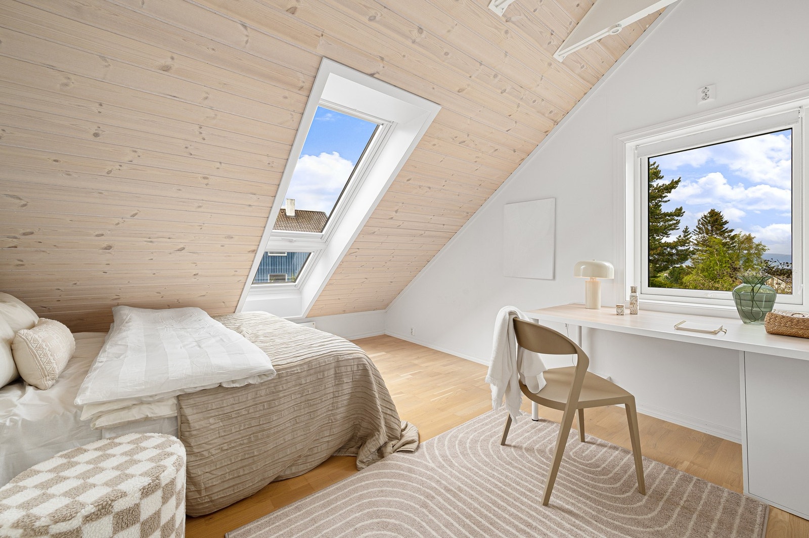 Lyst og delikat soverom med skråtak og praktisk plass til skrivepult ved vinduet. Galleribilde