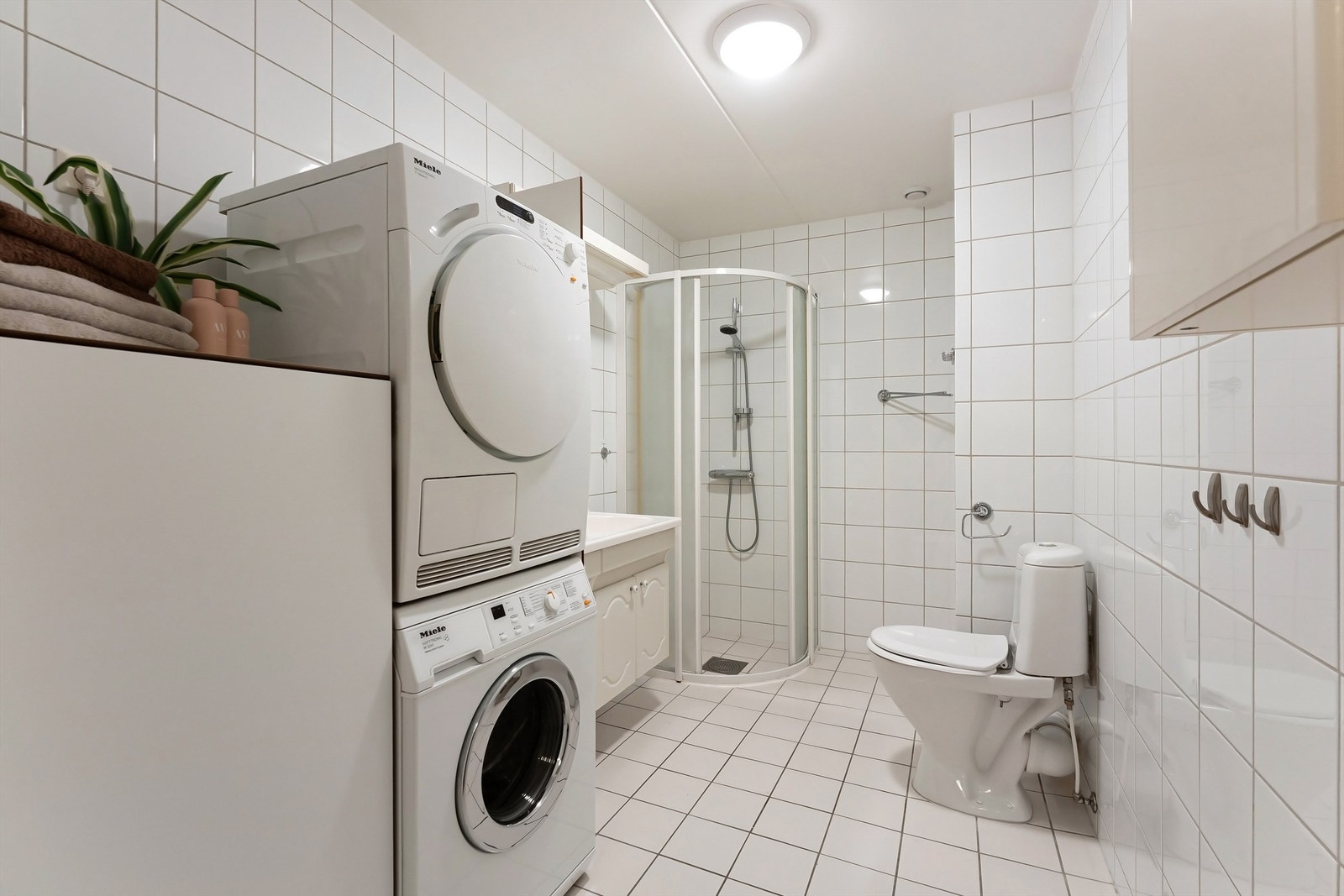 Baderom med fliser på gulv med gulvvarme, fliser på vegger og malt murhimling Galleribilde