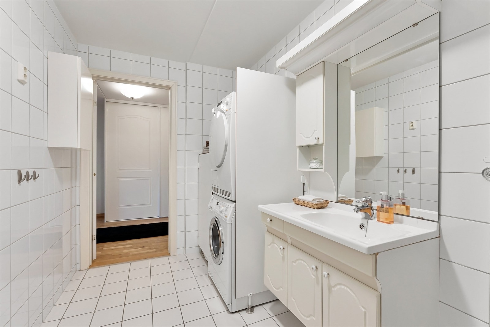 Badet har toalett, vegghengt servantskap med ovenpåliggende servant, speil og belysning over servant, veggskap, dusjsone med delvegger og skyvedører og opplegg for vaskemaskin/tørketrommel Galleribilde