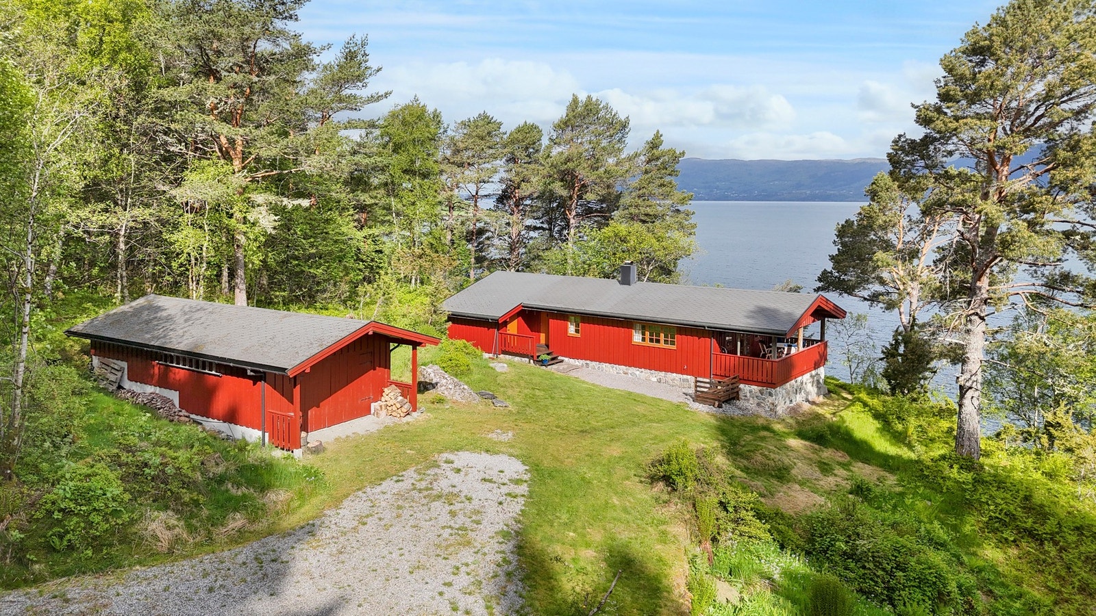 Eiendommen har pent tillaget tunareal med hytte og garasje/uthus Galleribilde