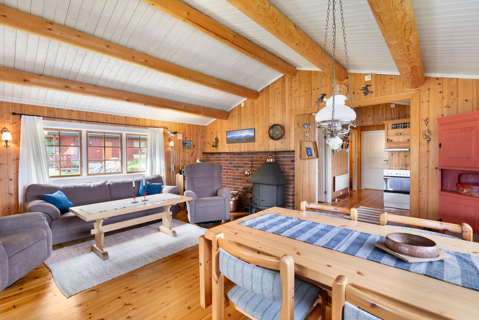 Stuen har også montert ildsted, og utgang til veranda med tofløyet verandadør Galleribilde