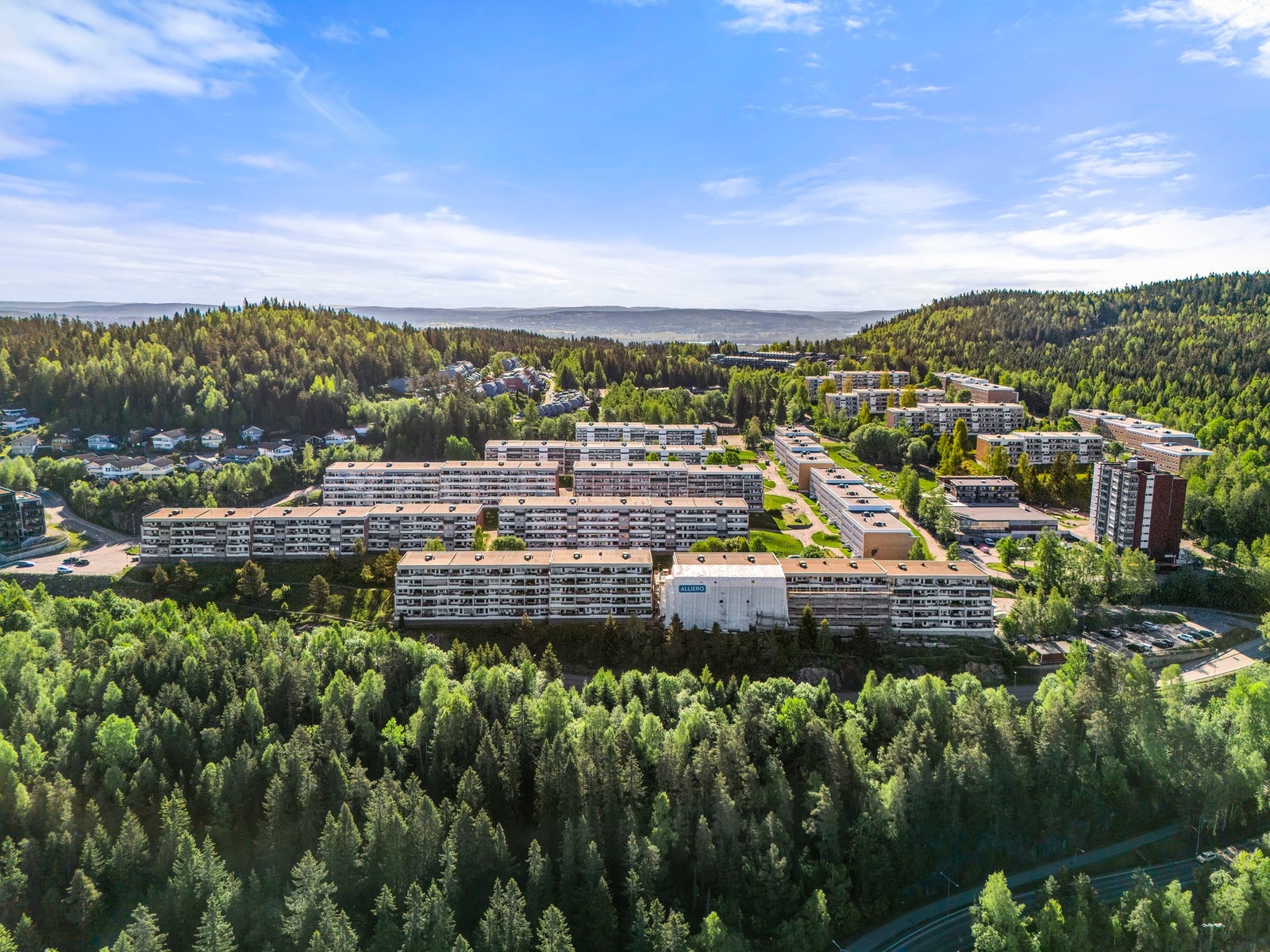 Fine grøntarealer utenfor innganspartiet med sittebenk og lekeplass. Galleribilde