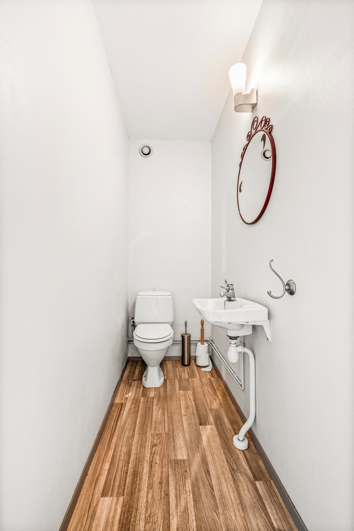 Separat WC innredet med toalett, servant med overspeil og belysning. Galleribilde