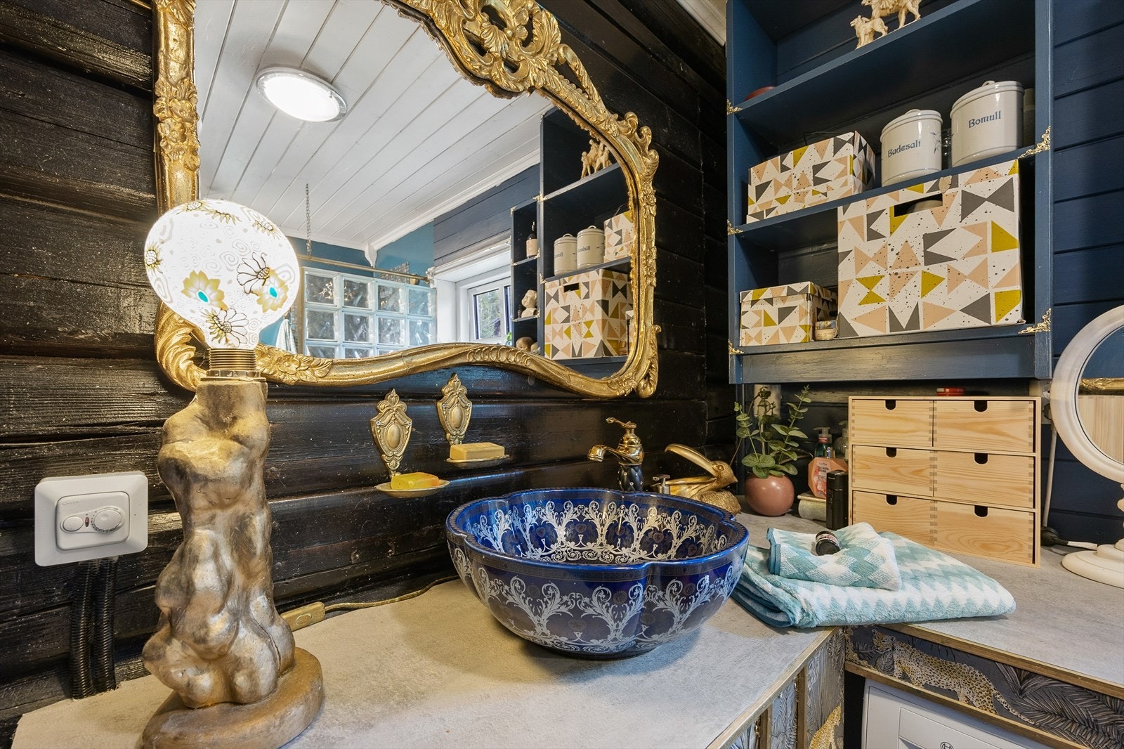 Badet har overflater av fliser i dusjhjørne, belegg på gulv og panel på vegger/tak. Galleribilde