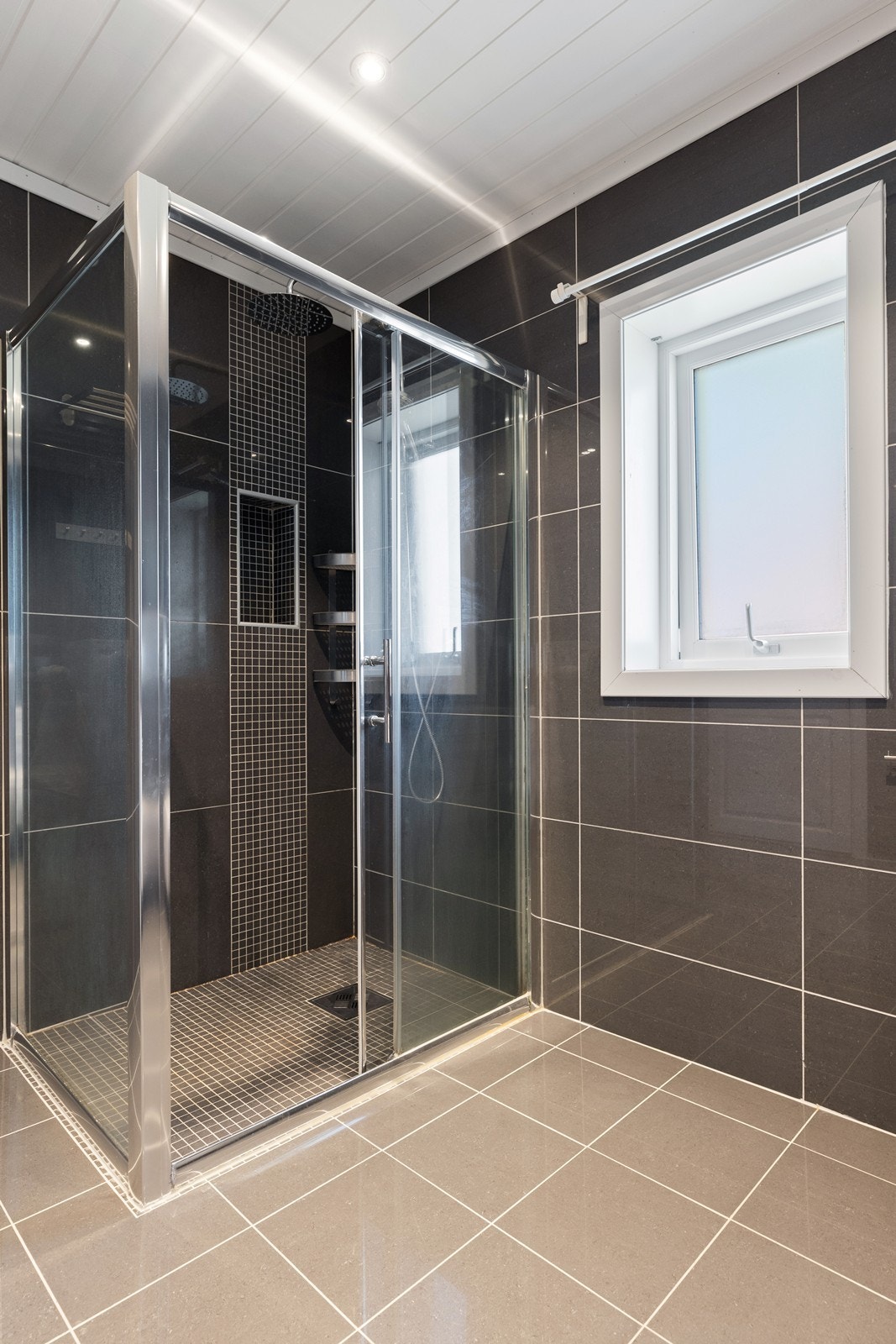 1. etasje - Badet har fliser på gulv og vegger, samt praktisk dusjhjørne med skyvedør. Galleribilde