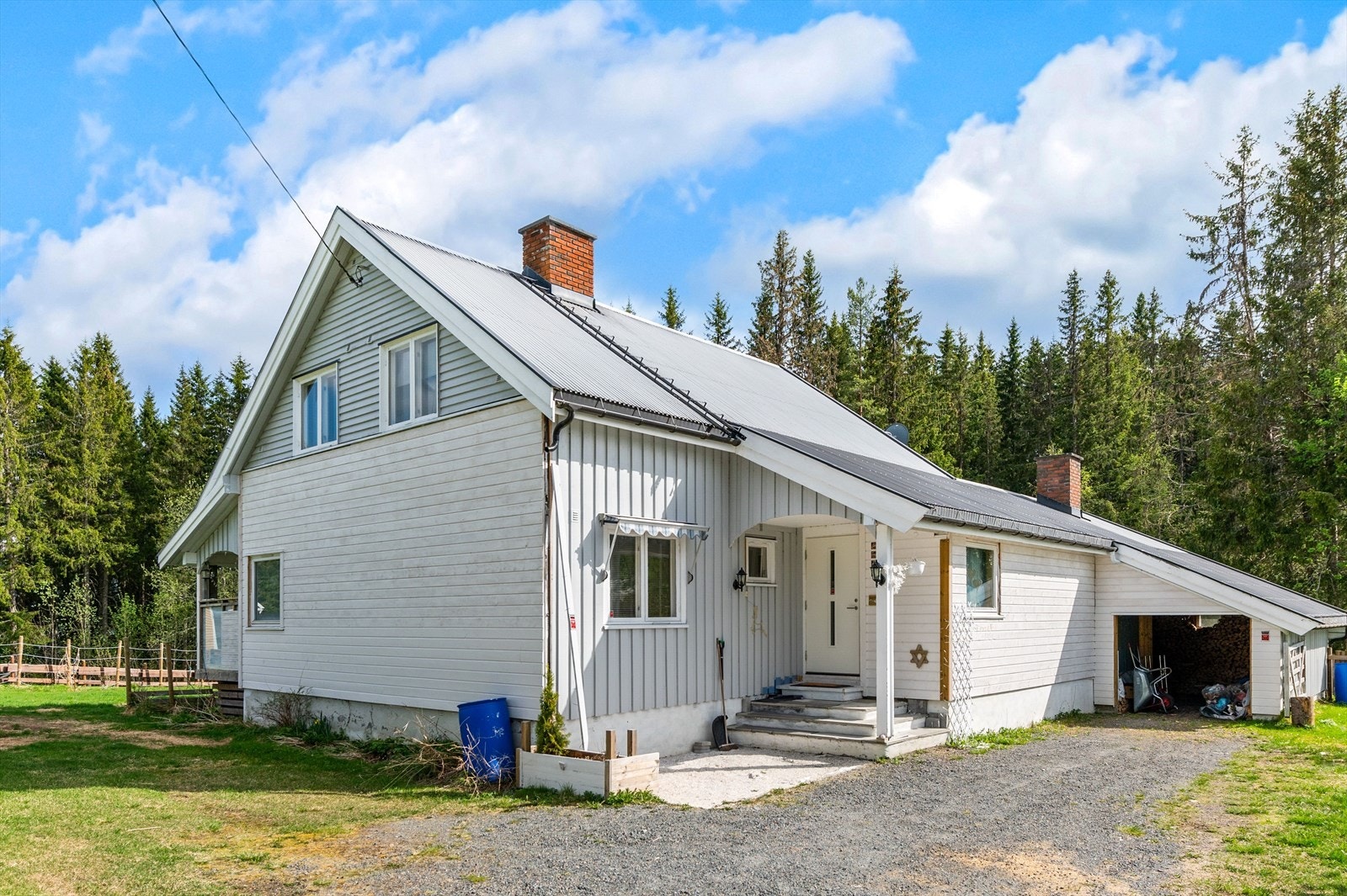 Fasade av boligen og gårdsplass. Inntilbygget garasje/bod/vedskåle Galleribilde