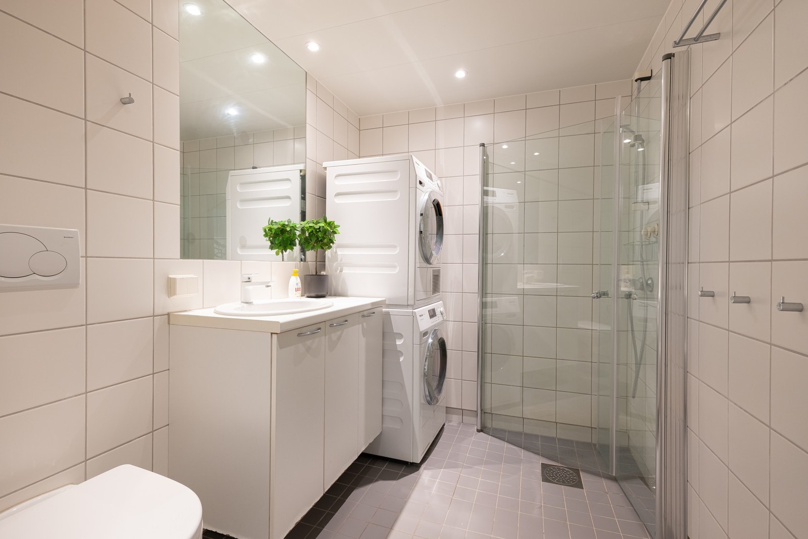 Lyst, flislagt bad med varme i gulv og downlights i himling. Det er opplegg for vaskemaskin. Galleribilde