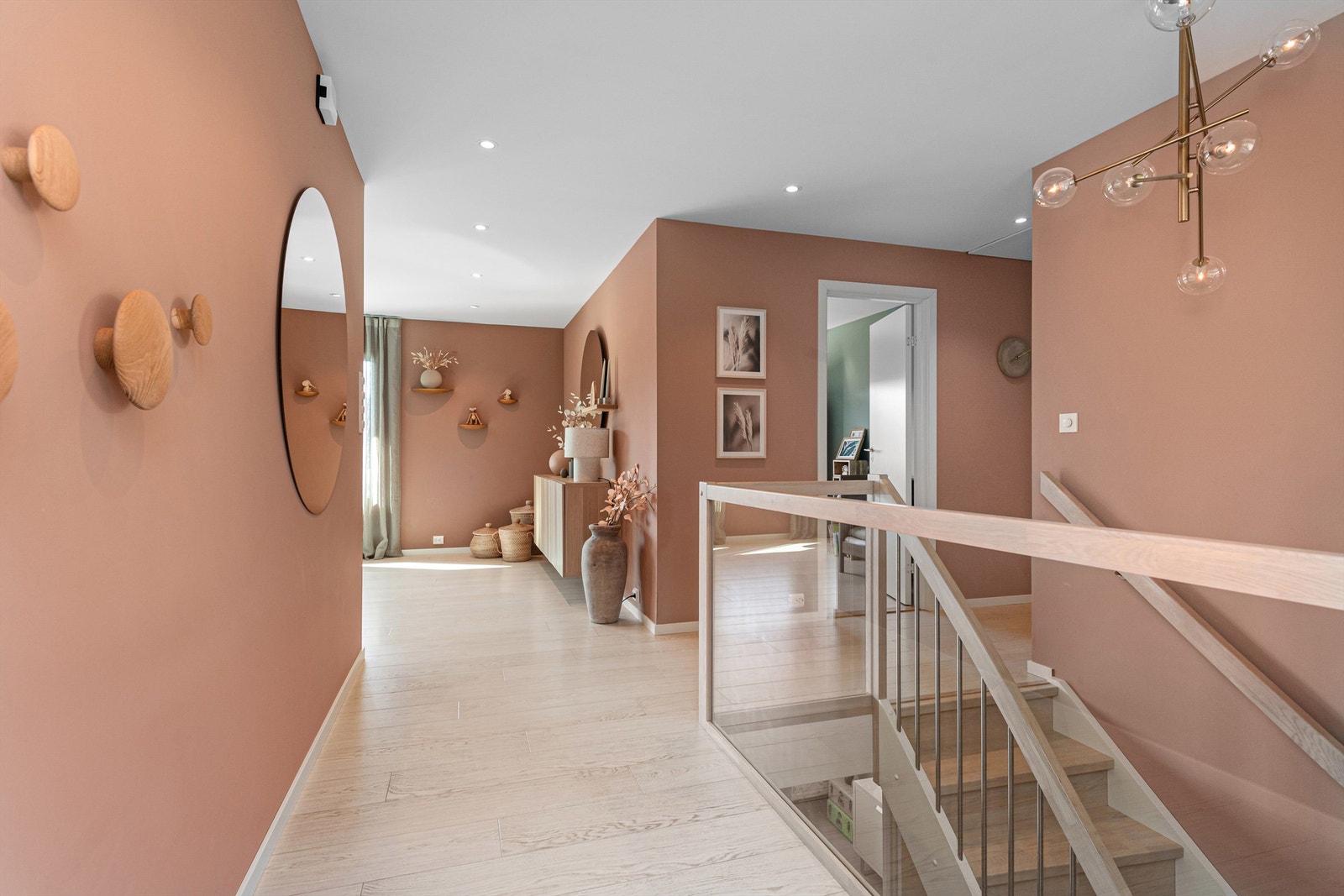 Innvendig trapp av tre med rekkverk av glass/metall mellom etasjene. Galleribilde