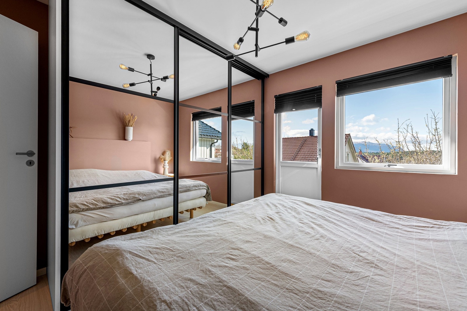 Skyvedørsgarderobe på hovedsoverom i hovedetasjen med sort omramming og speilfronter. Persienner i vindu. Galleribilde